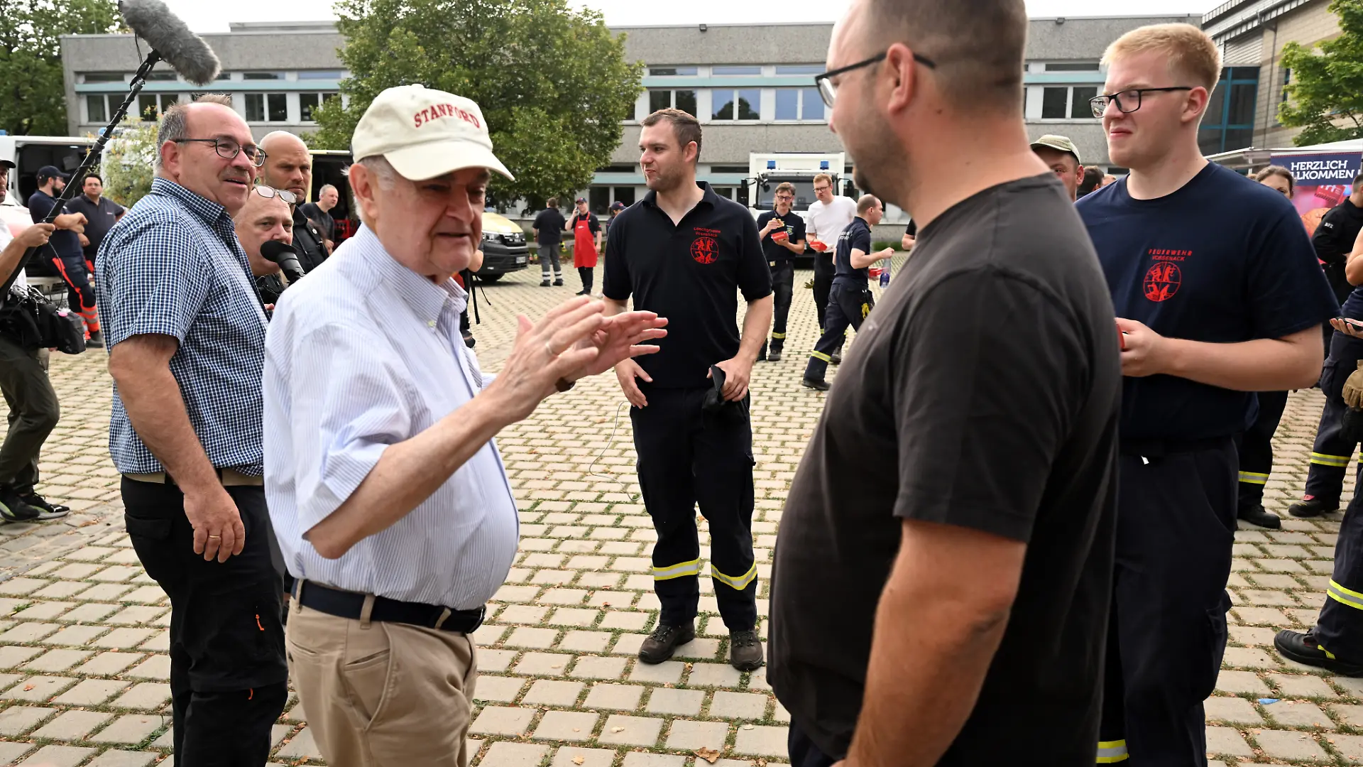 Herbert Reul (l, CDU), Innenminister von Nordrhein-Westfalen, spricht mit dem Martin Nießen von der Freiwilligen Feuerwehr Vossenack bei seinem Besuch im Waldbrandgebiet im Hürtgenwald. Beim Waldbrand im Hürtgenwald stehen mehrere Hundert Hektar Waldfläche in Flammen.