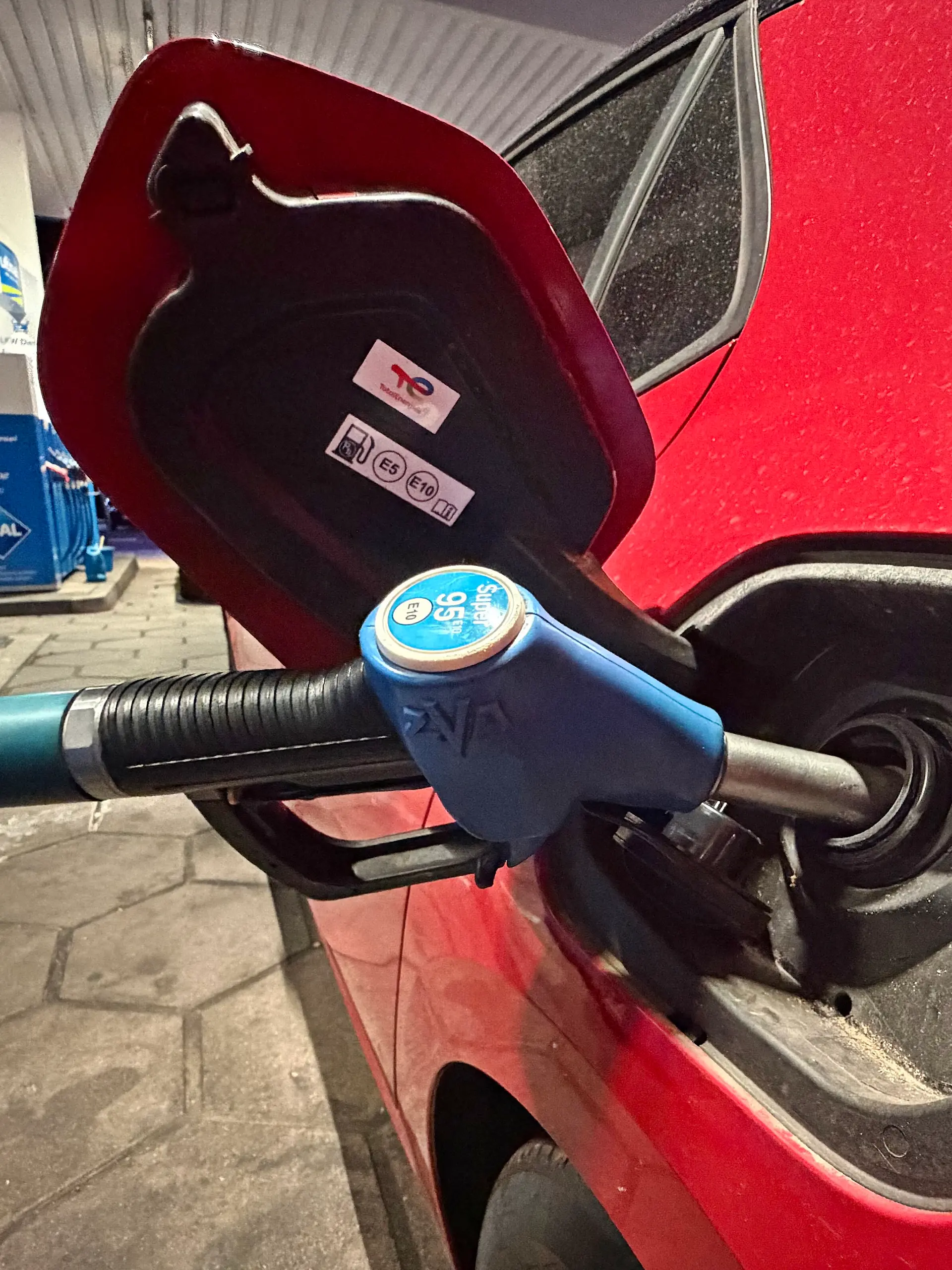 10.08.2026, Wirtschaft v.l. Auf diesem Foto ist ein Tankvorgang an einer Aral-Tankstelle zu sehen. Die Zapfpistole für Super 95 E10 steckt im Tankstutzen eines roten Pkw. Das Motiv kann symbolisch für Benzinpreise, steigende Spritkosten, Kraftstoffversorgung, Tanken und Mobilitätskosten stehen.