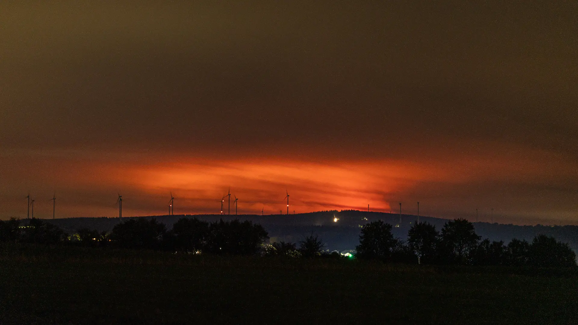 Nachtaufnahme: Waldbrand im Hohen Venn hinter Windkrafträdern bei Kleinhau