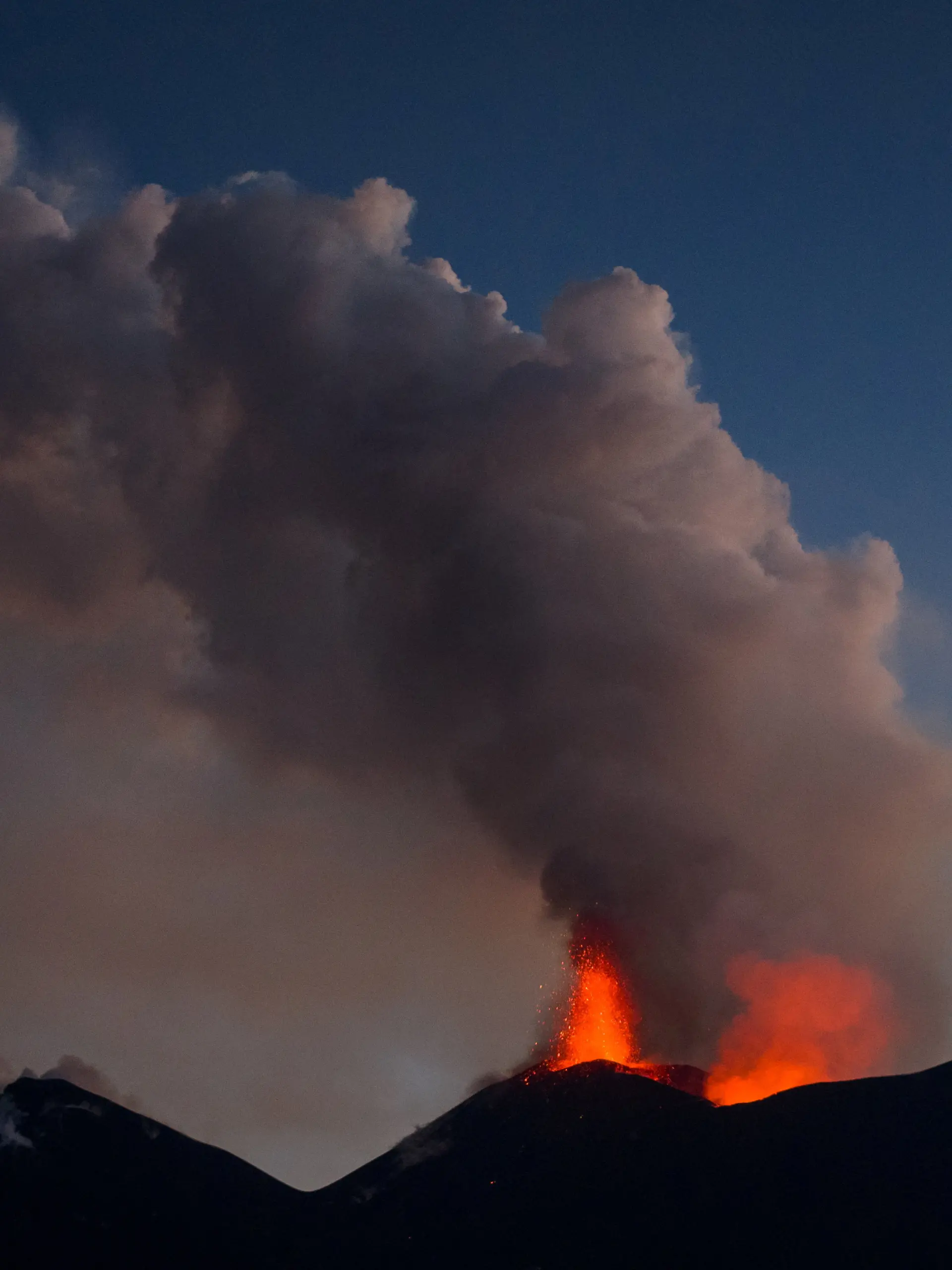 A drone view shows lava being ejected from a crater beneath a plume of volcanic fumes during an eruption of Mount Etna at dusk, in Sicily, Italy, August 13, 2026. REUTERS/Giuseppe Di Stefano