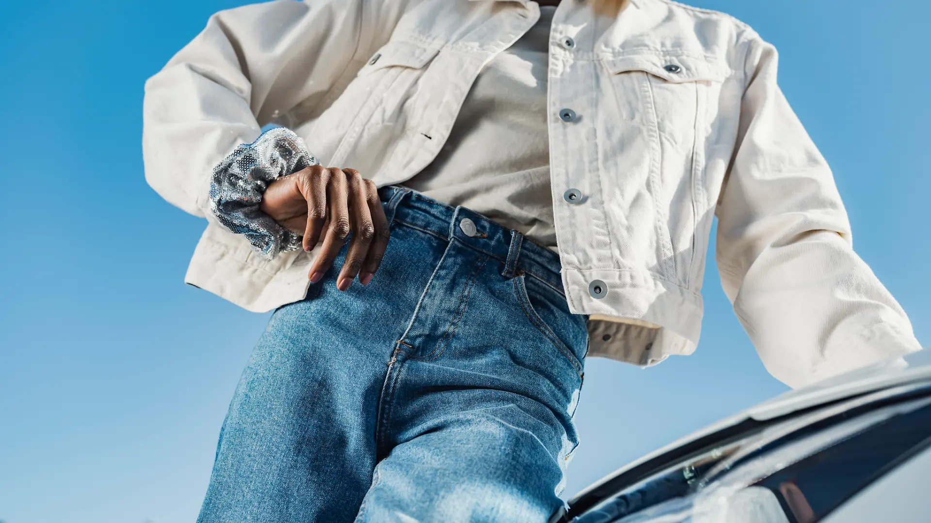 Nahaufnahme einer Frau in Jeansjacke und Jeans.