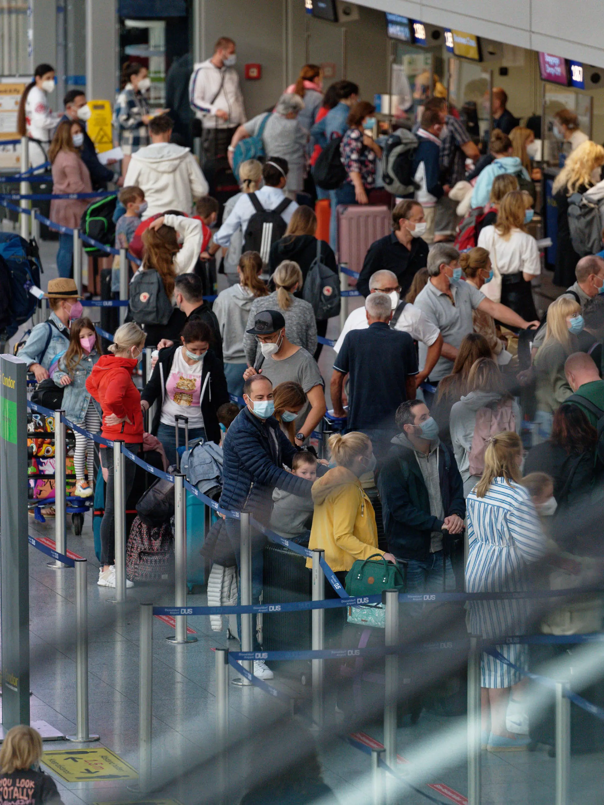 03.07.2021, Nordrhein-Westfalen, Düsseldorf: Reisende stehen im Flughafen Düsseldorf vor einem Schalter in einer Schlange. Foto: Henning Kaiser/dpa +++ dpa-Bildfunk +++