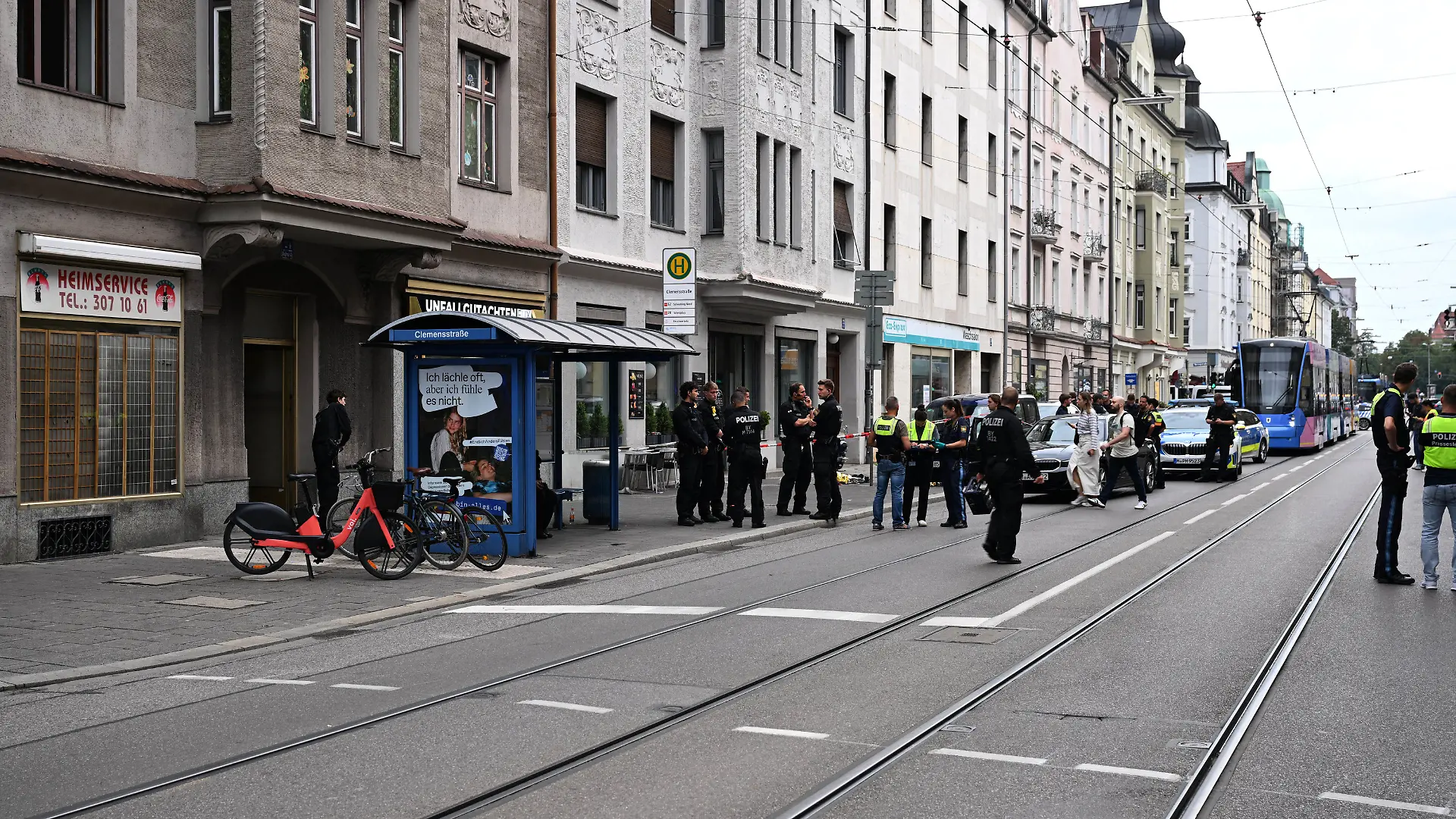 18.08.2026, Bayern, München: Viele Polizisten stehen am Tatort. Im Münchner Stadtteil Schwabing ist es zu einem polizeilichen Schusswaffengebrauch gekommen. Eine Person sei schwer verletzt ins Krankenhaus gebracht worden, berichtete ein Polizeisprecher. Warum geschossen wurde, sei noch unklar, man stehe ganz am Anfang. Foto: Felix Hörhager/dpa +++ dpa-Bildfunk +++