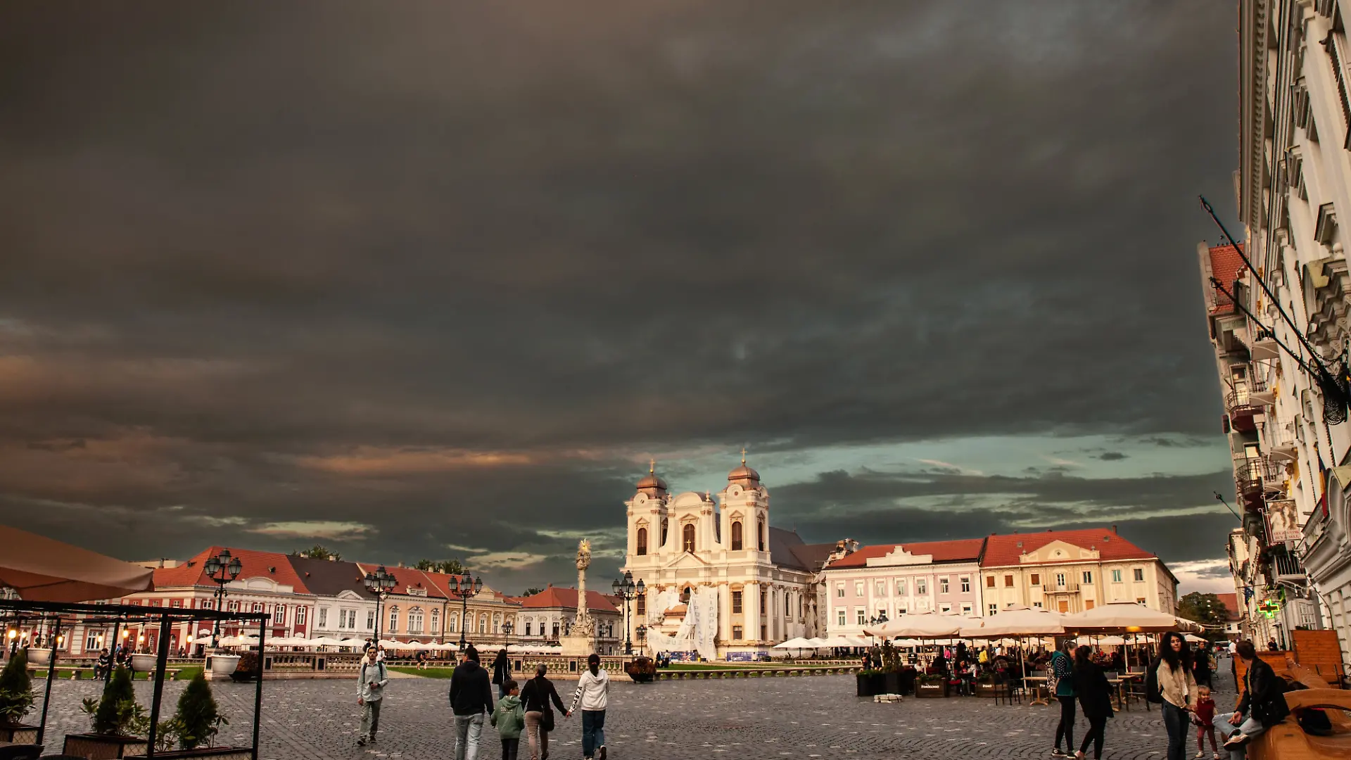 TIMISOARA, ROMANIA - SEPTEMBER 16, 2022: Panorama of Piata unirii square at dusk with typical Baroque Architecture, and sfantul gheorghe cathedral. Called union square, piata unirii is a landmark of Timisoara.