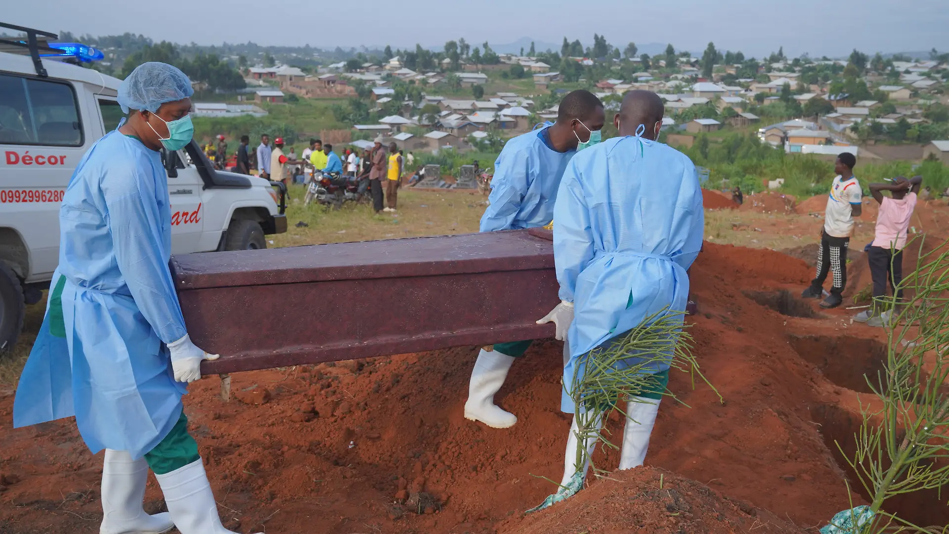 Menschen in Schutzkleidung laden einen Sarg mit den sterblichen Überresten eines sechsjährigen Kindes, das an Ebola gestorben ist, für eine Beerdigung in Bunia in der Provinz Ituri im Osten der Demokratischen Republik Kongo ab. +++ dpa-Bildfunk +++