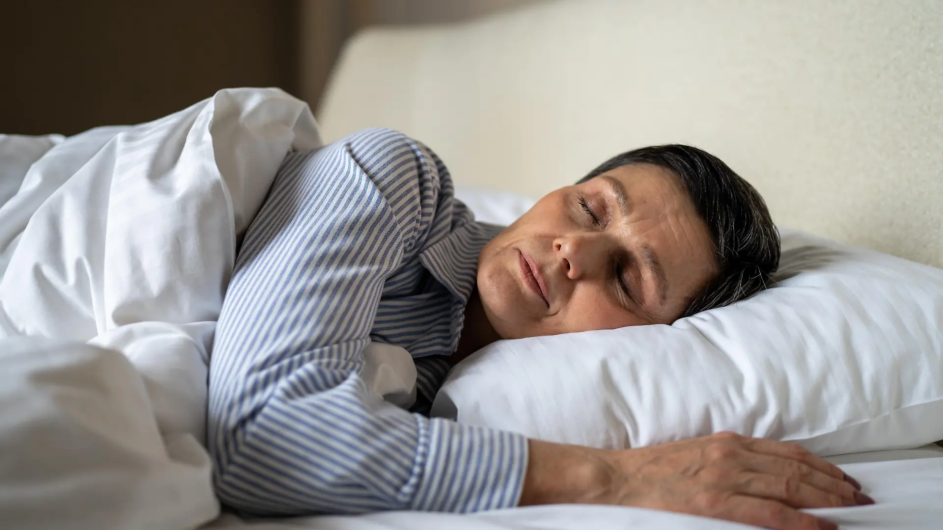 Tranquil senior woman comfy lying in bed in bedroom at home covered in blanket and sleeping, relaxed elderly mature female sleeps with pillow healthcare and mental energy, aged lady resting in bed.