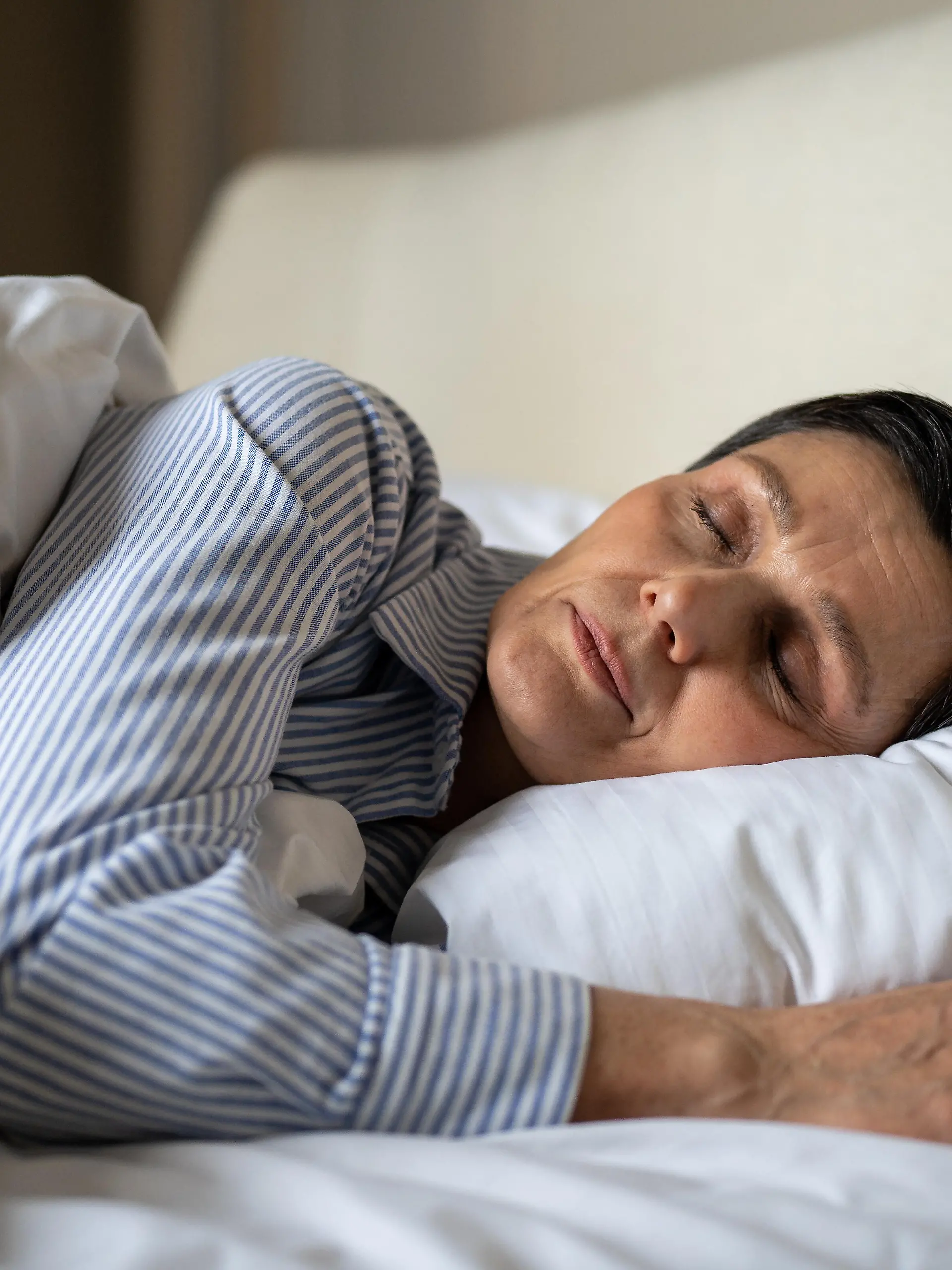 Tranquil senior woman comfy lying in bed in bedroom at home covered in blanket and sleeping, relaxed elderly mature female sleeps with pillow healthcare and mental energy, aged lady resting in bed.