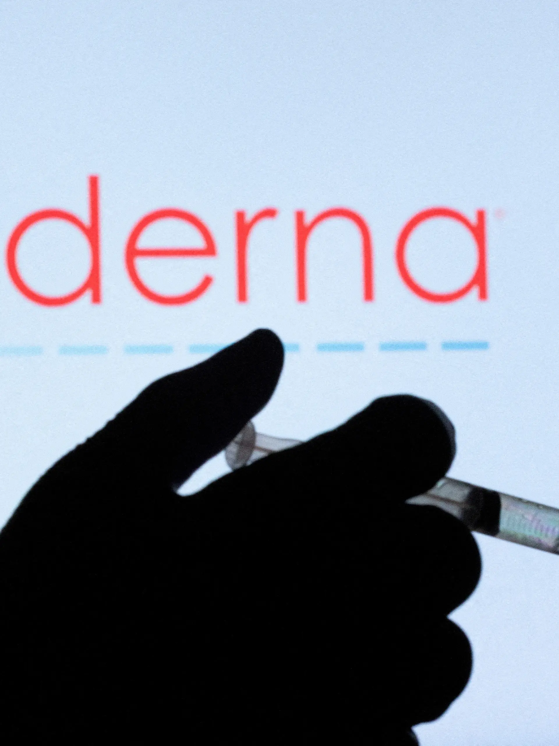 FILE PHOTO: People pose with syringe with needle in front of displayed Moderna logo in this illustration taken, December 11, 2021. REUTERS/Dado Ruvic/Illustration/File Photo
