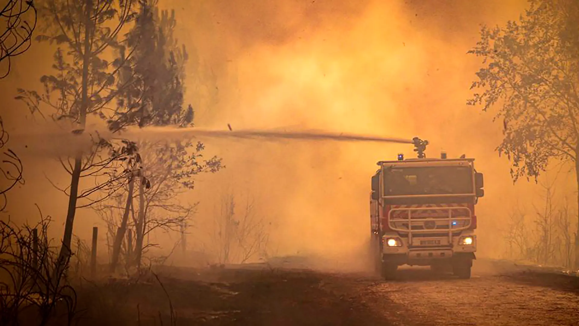 ARCHIV - 15.07.2022, Frankreich, Landiras: Dieses am Freitag, den 15. Juli 2022, von der Feuerwehr der Region Gironde (SDIS 33) zur Verfügung gestellte Foto zeigt einen Feuerwehrwagen, der Flüssigkeit auf einen Waldbrand sprüht. Mehrere hundert Feuerwehrleute bemühten sich am 15.07.2022, zwei Waldbrände in der Region Bordeaux im Südwesten Frankreichs einzudämmen, die die Evakuierung von 10 000 Menschen erzwungen und mehr als 7 000 Hektar Land verwüstet haben. Hohe Temperaturen und starke Winde haben die Löscharbeiten in der Region erschwert, die in dieser Saison von mehreren Waldbränden in Europa heimgesucht wird. (zu dpa: «Klimawandel könnte Waldbrandfläche in Europa verdreifachen») Foto: Uncredited/Service Communication-Protocole SDIS 33/AP/dpa +++ dpa-Bildfunk +++