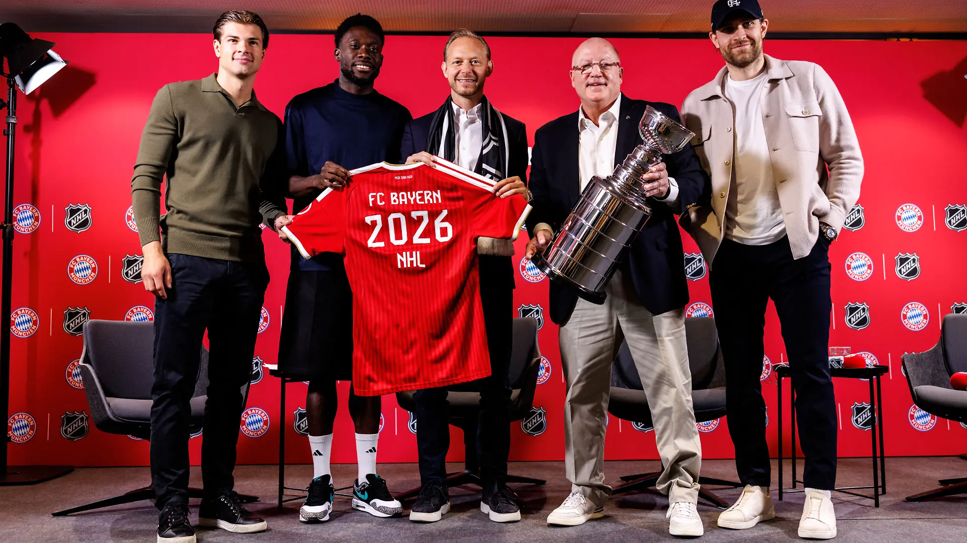 Eishockey, Fußball: Gemeinsame Pk des FC Bayern München und der National Hockey League (NHL). John-Jason Peterka (l-r), Boston Bruins, Alphonso Davies, Spieler vom FC Bayern München, Rouven Kasper, Vorstand Marketing und Vertrieb der FC Bayern München AG, Bill Daly, stellvertretender Commissioner der NHL, und Leon Draisaitl, Spieler der Edmonton Oilers, posieren bei der Pressekonferenz. +++ dpa-Bildfunk +++