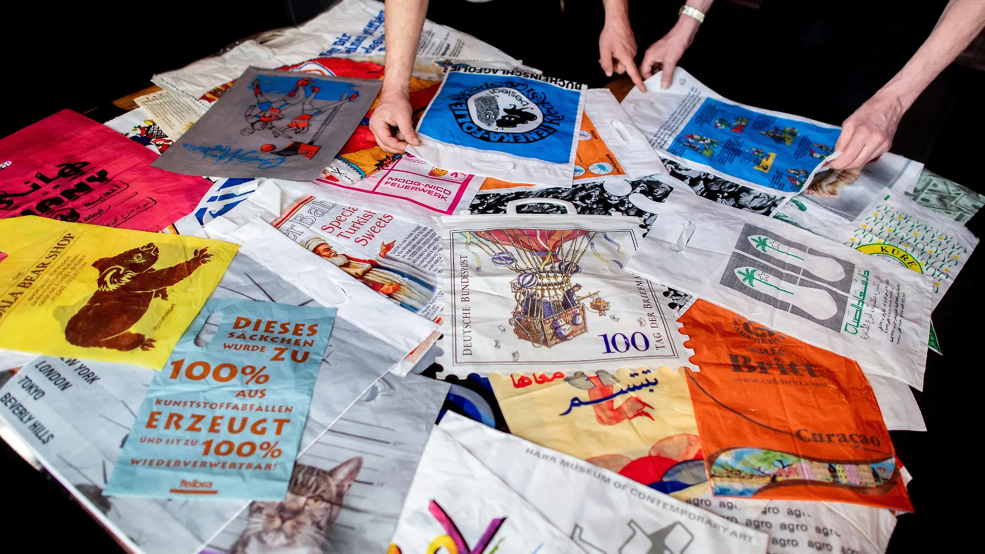 PRODUKTION - 08.05.2023, Bremen: Elard Lukaczik (l), Vorstand der Genossenschaft in der Kneipe ·Horner Eck· und Kurator der Ausstellung, wählt mit Sammler Jürgen Francke Plastiktüten für die Ausstellung aus. Jürgen Francke aus Bremen hat in rund 50 Jahren über 60.000 Plastiktüten gesammelt. In der Kneipe ·Horner Eck· wird eine Auswahl seiner Sammlung gezeigt. Foto: Hauke-Christian Dittrich/dpa +++ dpa-Bildfunk +++
