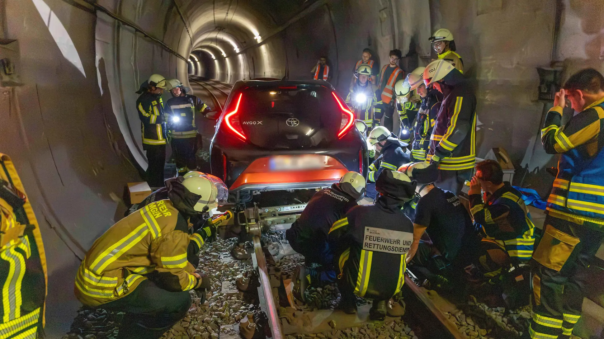 Feuerwehrleute arbeiten an einem Auto, das in einem U-Bahn-Tunnel steckt. Eine Frau ist in Bochum mit ihrem Auto rund einen Kilometer weit in einen U-Bahn-Tunnel gefahren. +++ dpa-Bildfunk +++