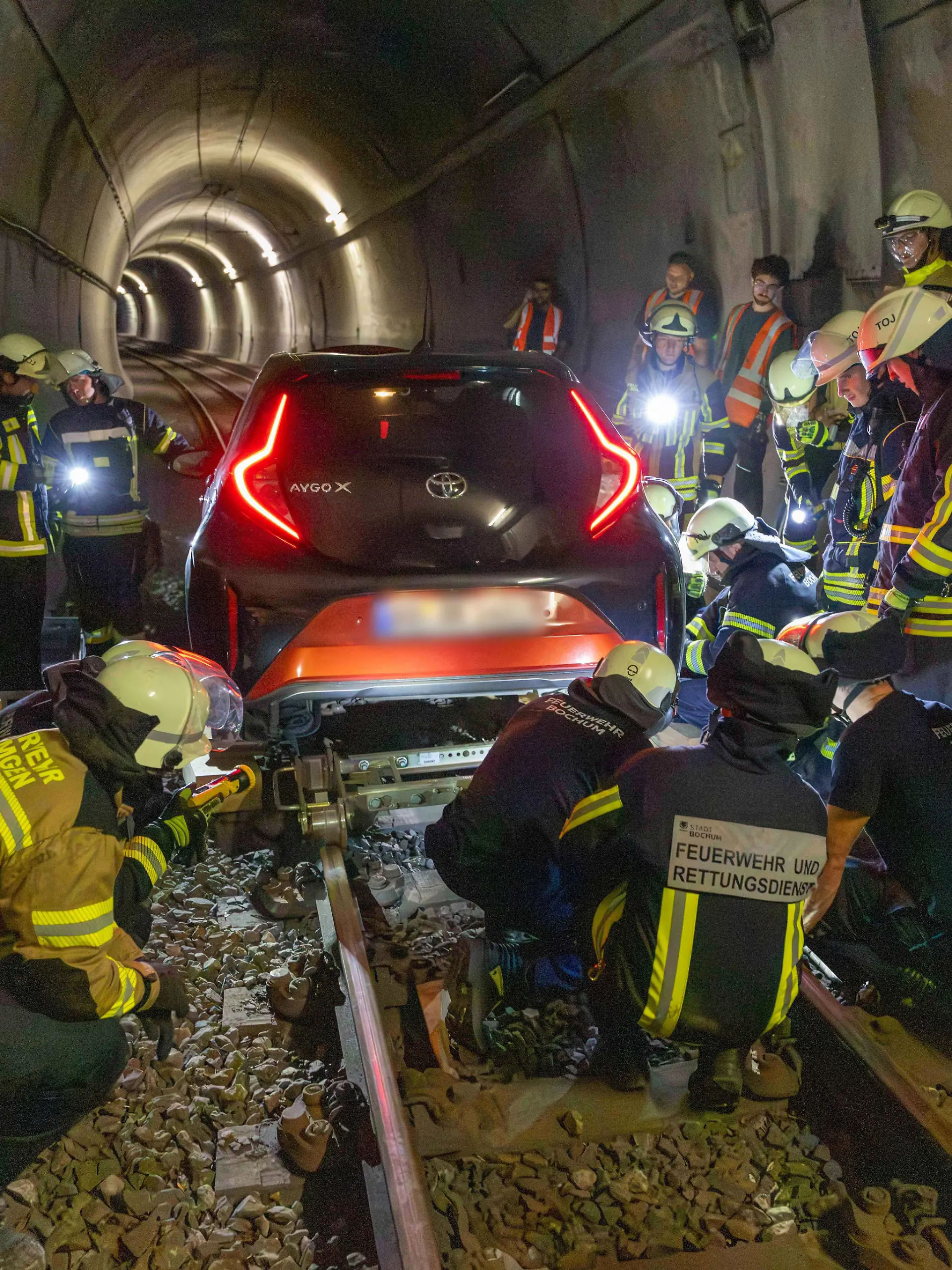 Feuerwehrleute arbeiten an einem Auto, das in einem U-Bahn-Tunnel steckt. Eine Frau ist in Bochum mit ihrem Auto rund einen Kilometer weit in einen U-Bahn-Tunnel gefahren. +++ dpa-Bildfunk +++