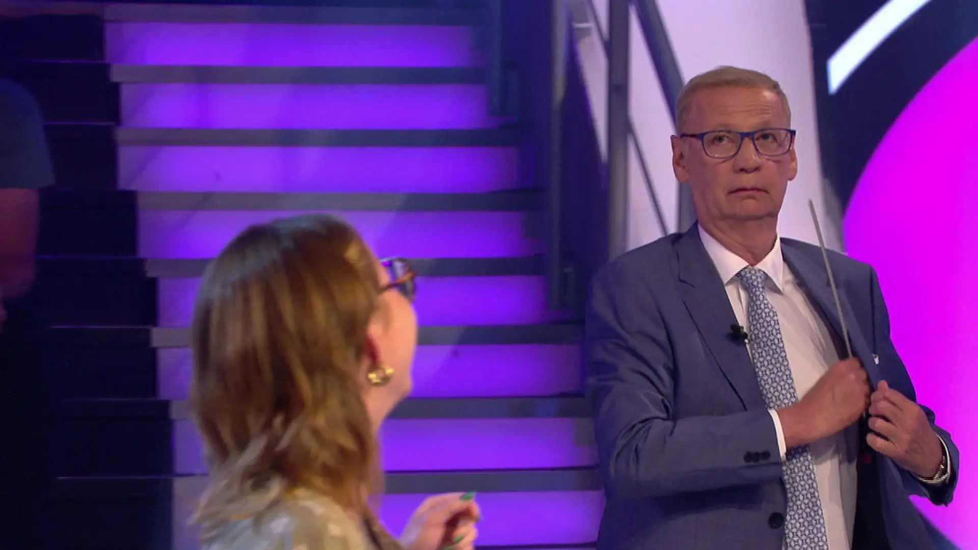 Günther Jauch versucht, eine abgerissene Leiste vom WWM-Studio in seiner Jacke zu verstecken.