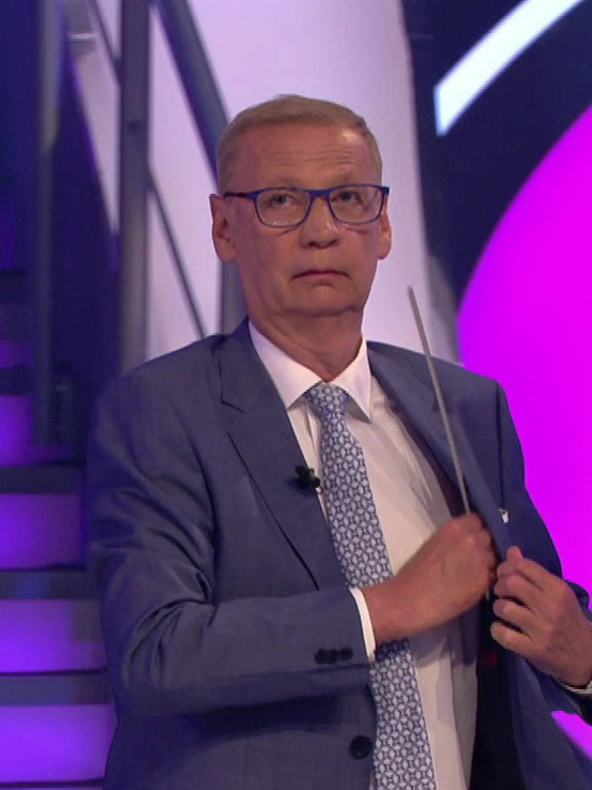 Günther Jauch versucht, eine abgerissene Leiste vom WWM-Studio in seiner Jacke zu verstecken.