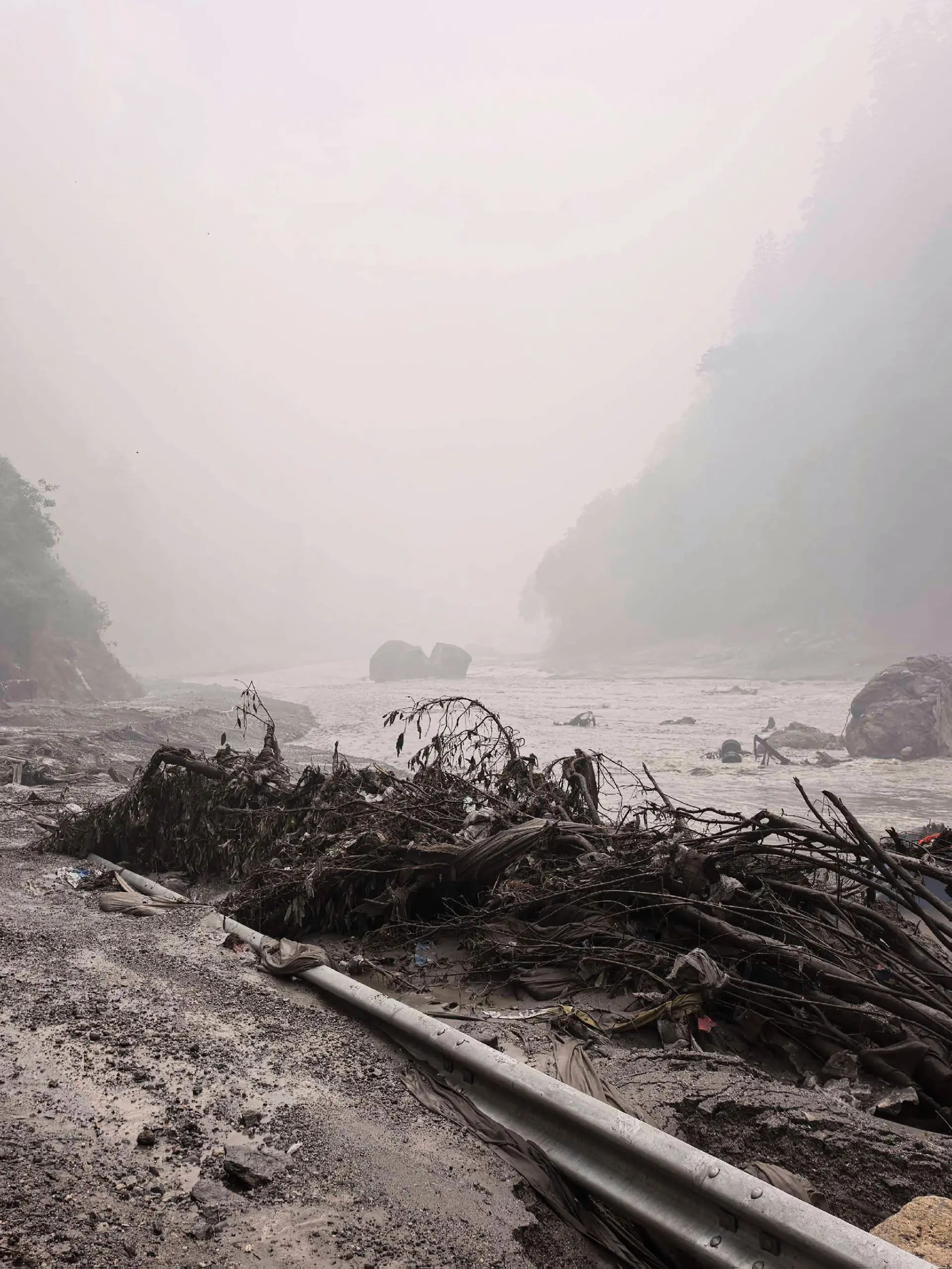 26.08.2026, China, Tibet: Auf diesem von der Nachrichtenagentur Xinhua veröffentlichten Foto ist ein schlammiges Flussufer mit Trümmern in der Nähe des Hafens von Gyirong in der Autonomen Region Tibet im Südwesten Chinas zu sehen. Foto: Anonymous/Xinhua/AP/dpa +++ dpa-Bildfunk +++