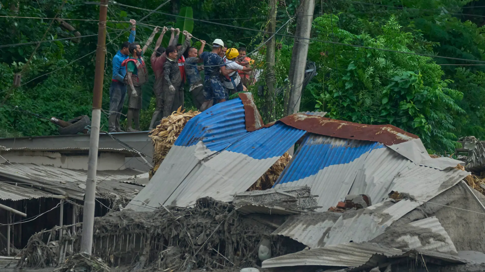 Rettungskräfte spannen ein Seil, um nach Überlebenden zu suchen, nachdem es im Bezirk Nuwakot in Nepal zu Sturzfluten entlang des Trishuli-Flusses gekommen war. +++ dpa-Bildfunk +++