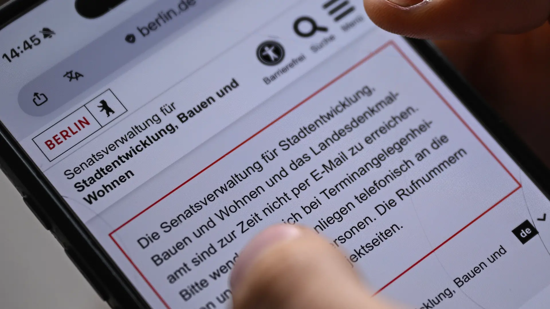 In dieser gestellten Aufnahme hält ein junger Mann ein Smartphone in der Hand, auf dem die Seite der Senatsverwaltung für Stadtentwicklung, Bauen und Wohnen aufmerksam macht, das diese zurzeit nicht erreichbar ist. (zu dpa: «Nach Hackerangriff: Senat kommt zu Sondersitzung zusammen») +++ dpa-Bildfunk +++