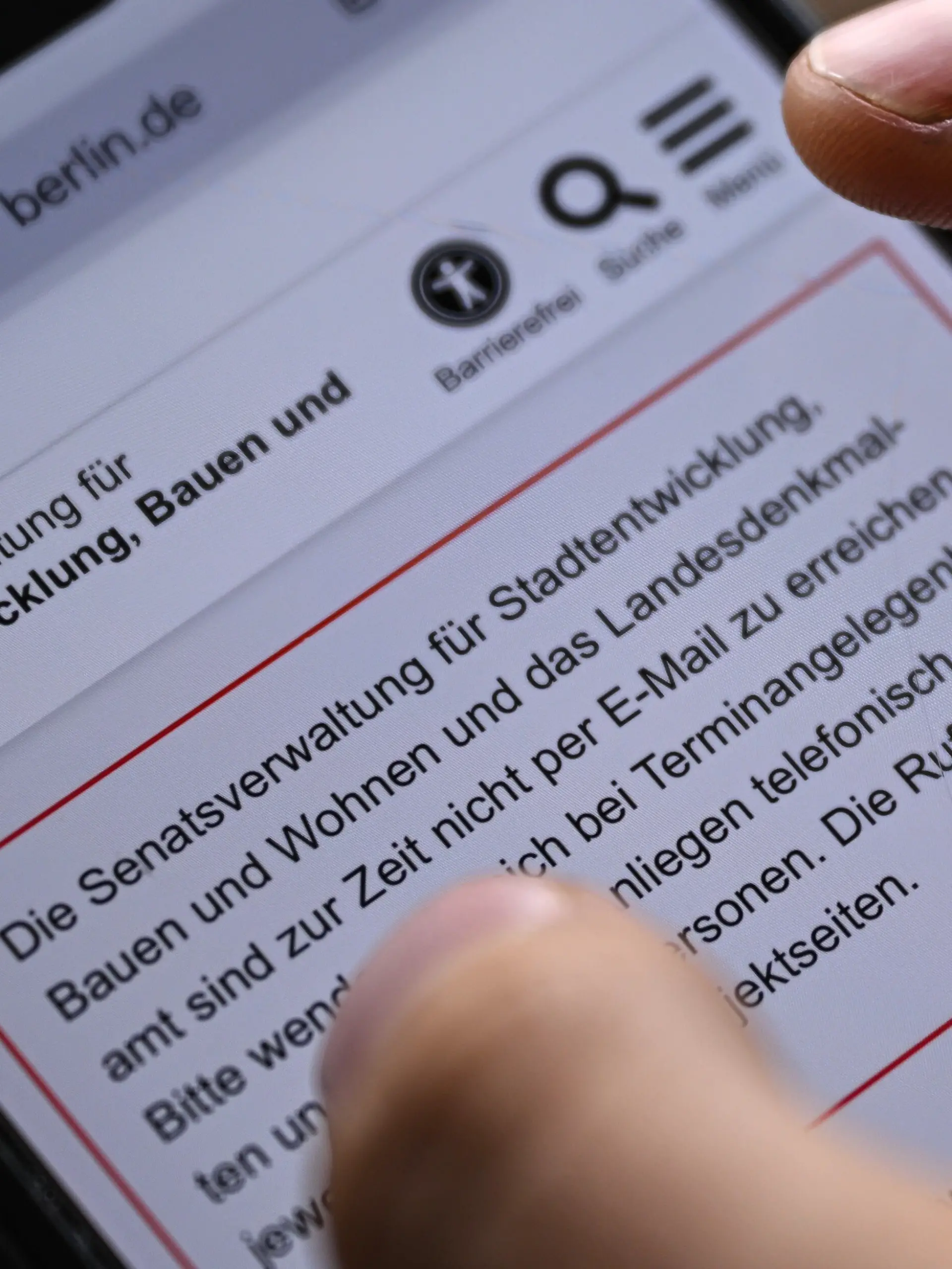In dieser gestellten Aufnahme hält ein junger Mann ein Smartphone in der Hand, auf dem die Seite der Senatsverwaltung für Stadtentwicklung, Bauen und Wohnen aufmerksam macht, das diese zurzeit nicht erreichbar ist. (zu dpa: «Nach Hackerangriff: Senat kommt zu Sondersitzung zusammen») +++ dpa-Bildfunk +++