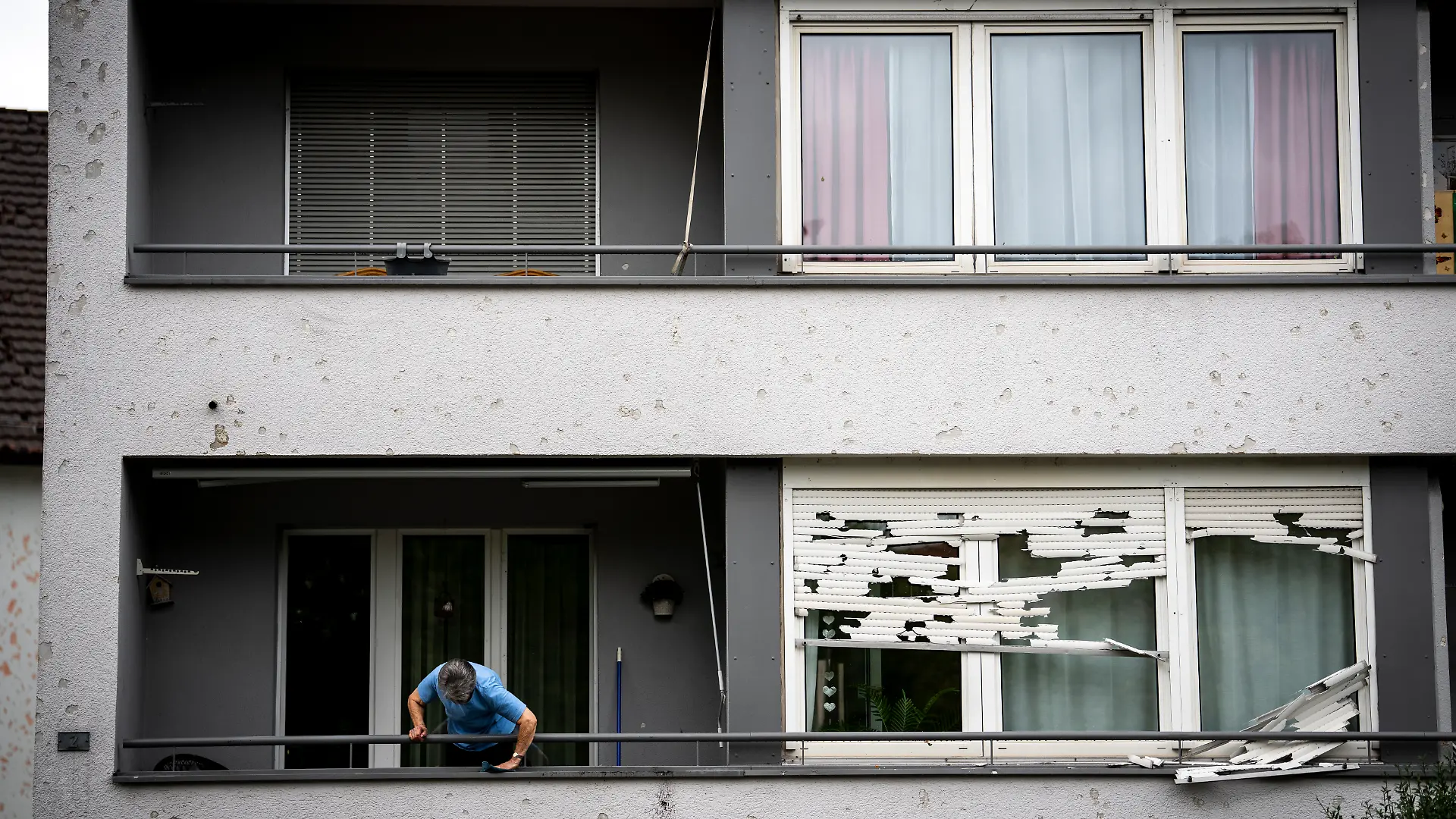 Eine Frau reinigt ihren Balkon nach dem heftigen Gewitter. Heftige Unwetter mit Hagel zogen über Teile der Kantone Aargau, Zürich und Schaffhausen hinweg und verursachten zahlreiche Schäden und Überschwemmungen. +++ dpa-Bildfunk +++