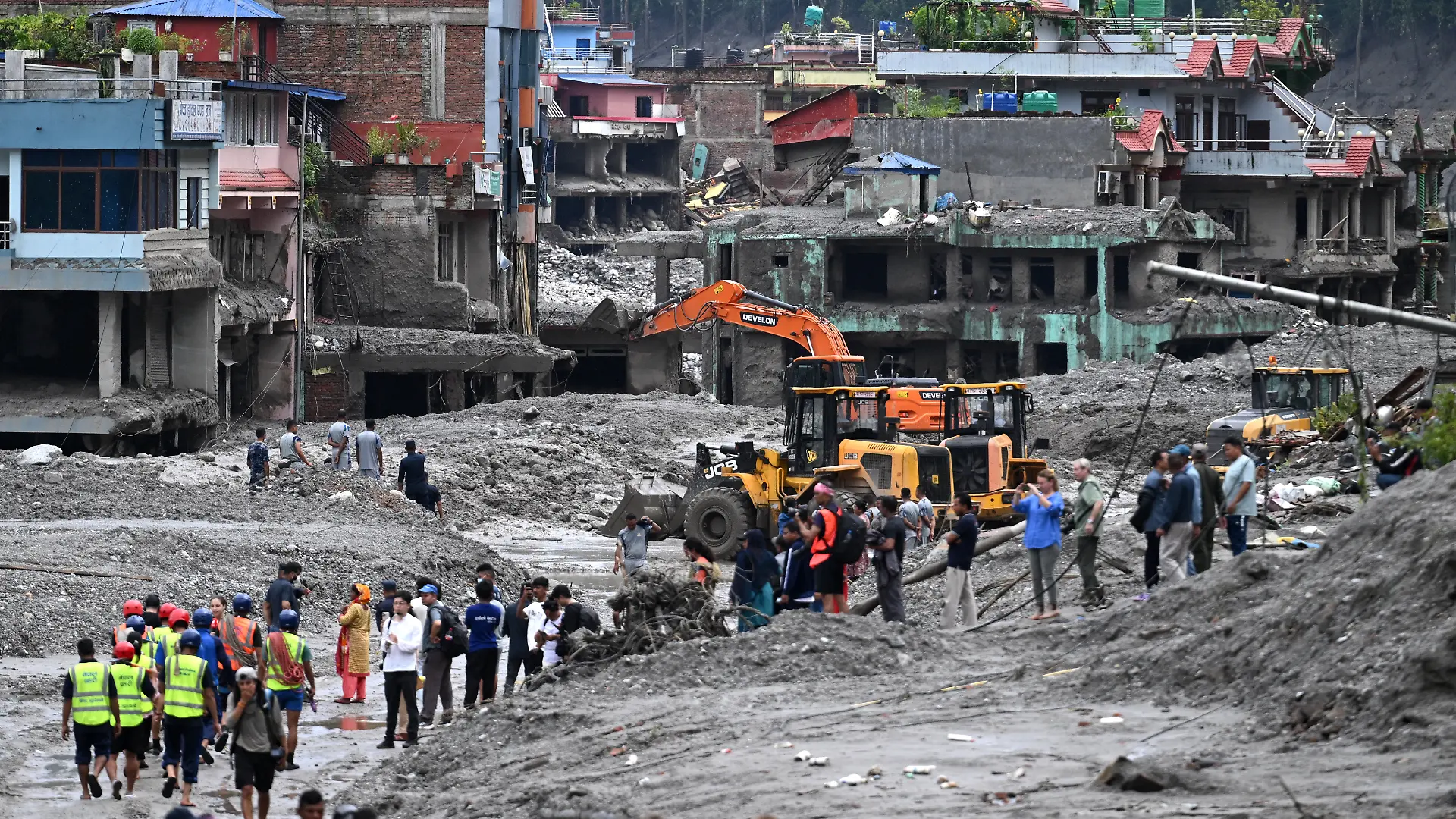 Arbeiter setzen Bagger ein, um nach den verheerenden Sturzfluten den Schlamm auf dem Dhunge-Basar im nepalesischen Distrikt Nuwakot zu beseitigen.