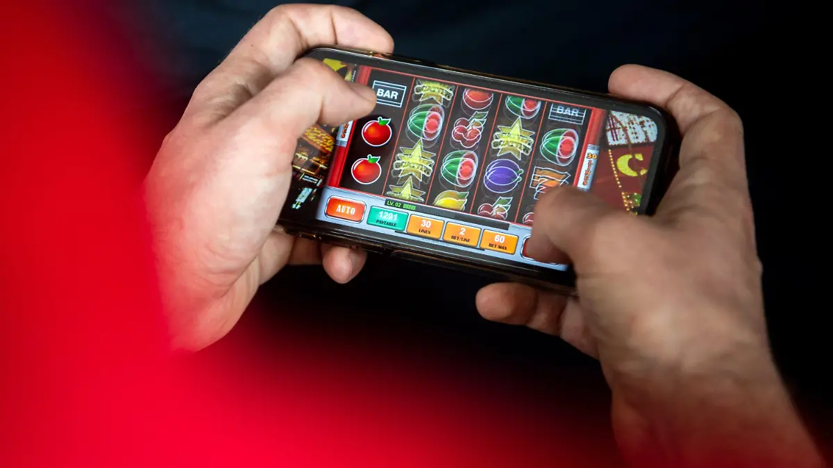 23.06.2021, Bremen: ILLUSTRATION - Auf einem Smartphone wird ein Online-Spiel gespielt. Mit dem neuen Glücksspielstaatsvertrag der am 1. Juli in Kraft tritt, werden bisher verbotene virtuelle Automatenspiele im Internet sowie Online-Casinos mit Poker oder Roulette erlaubt. Foto: Sina Schuldt/dpa +++ dpa-Bildfunk +++