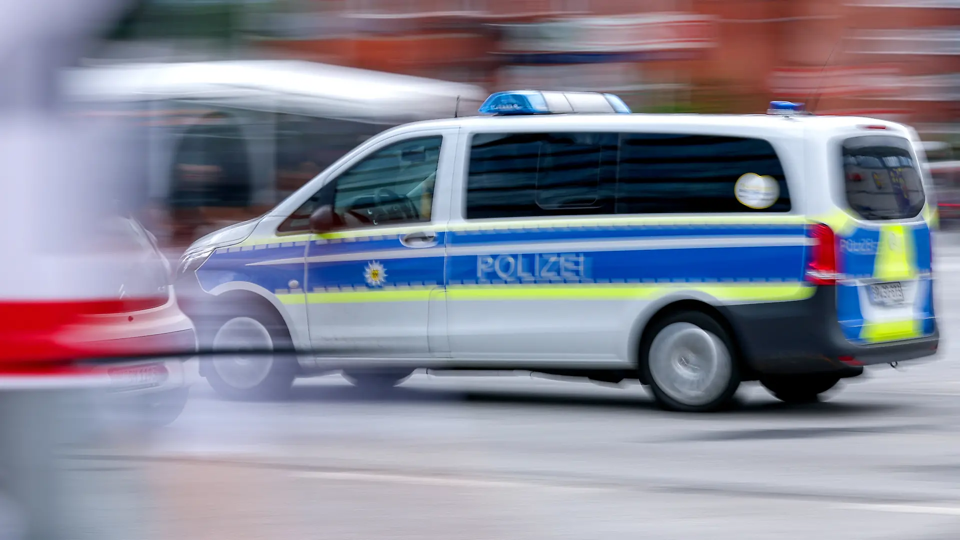 03.07.2026, Hamburg, Ein Polizeiauto fährt mit Blaulicht auf Einsatzfahrt durch eine Hamburger Straße