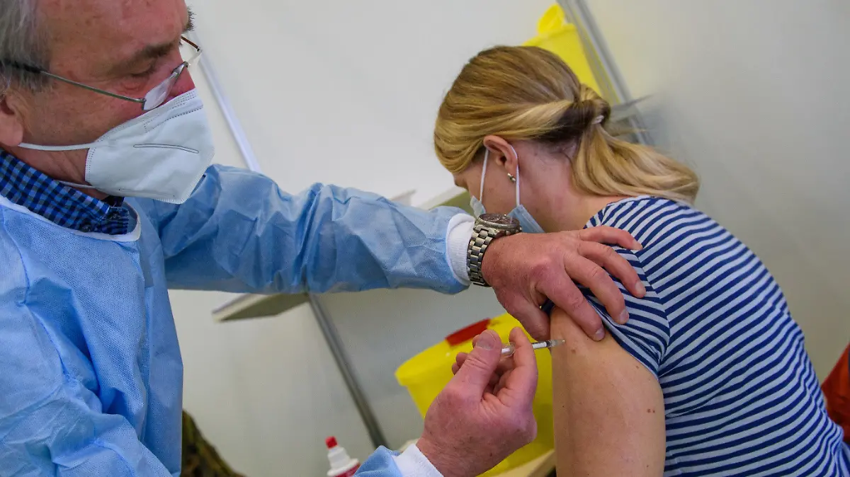 26.02.2021, Sachsen-Anhalt, Burg: Matthias Leske (l), Facharzt für Anästhesiologie, impft im Impfzentrum des Jerichower Landes eine Lehrerin mit dem Wirkstoff von Astra Zeneca gegen das Coronavirus. Nach der höheren Einstufung bei der Impfreihenfolge haben Lehrkräfte sowie Erzieherinnen und Erzieher im Landkreis seit dem Morgen die Möglichkeit, sich gegen Corona immunisieren zu lassen. Gestaffelt nach Gemeinden seien zu diesem Zweck Terminfenster im Impfzentrum in Burg eingerichtet worden. Damit solle möglichst viel pädagogisches Personal noch vor der Schulöffnung am 01. März 2021 die Chance auf eine Impfung bekommen. Foto: Klaus-Dietmar Gabbert/dpa-Zentralbild/dpa +++ dpa-Bildfunk +++