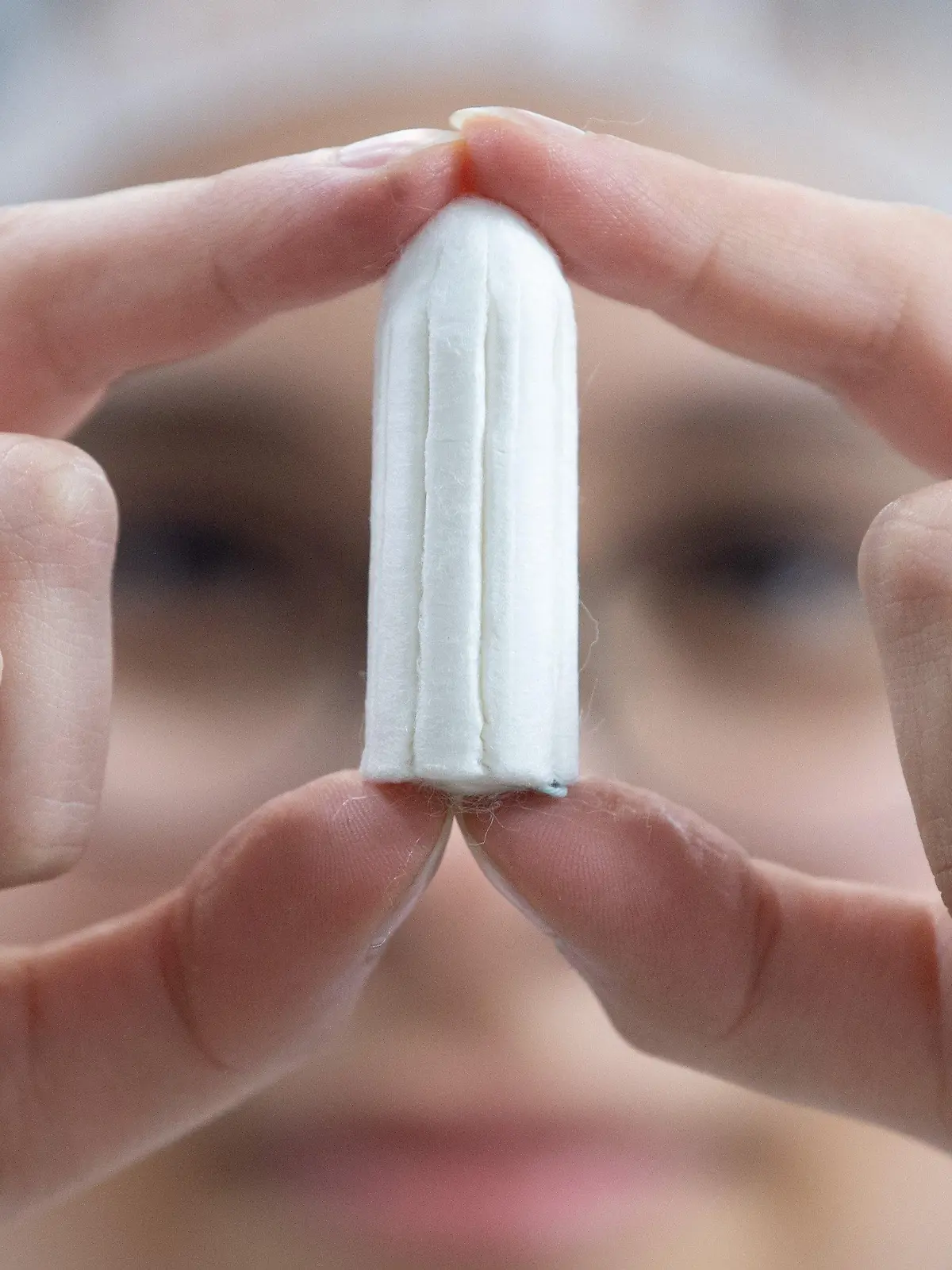 ARCHIV - 04.12.2019, ---: Ein Tampon wird von einer Angestellten in einer Produktionshalle gehalten. (Illustration zu dpa: "Binden und Tampons in Schottland bald kostenlos erhältlich") Foto: Sebastian Kahnert/dpa-Zentralbild/dpa +++ dpa-Bildfunk +++