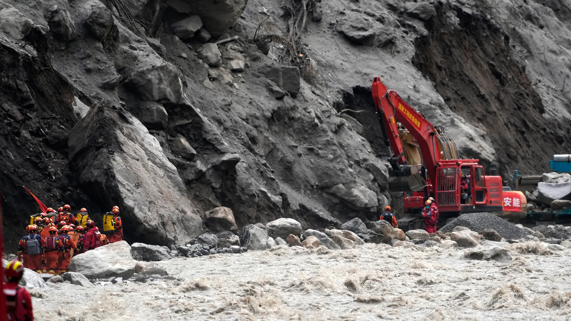 Chinese rescue personnel carrying supplies and equipment enter the core disaster area through a newly opened land route as excavators work at the destroyed Gyirong Port in Gyirong County, in China's western Tibet Autonomous Region, on September 2, 2026. (Photo by CNS / AFP) / China OUT
