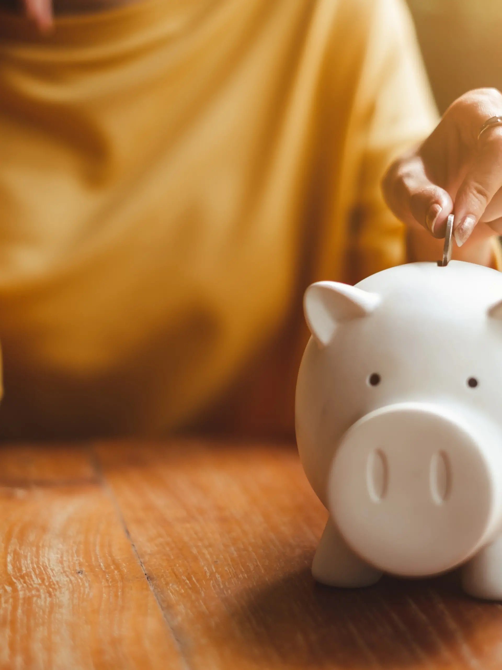 Eine Frau wirft Geld in ihr Sparschwein.