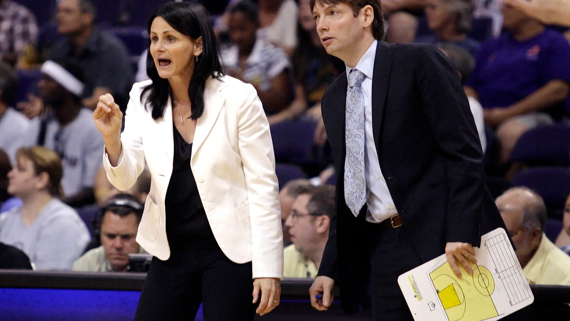 FILE - In this Aug. 26, 2010, file photo, San Antonio Silver Stars coaches Sandy Brondello, left, and Olaf Lange watch their team play against the Phoenix Mercury in Game 1 of the WNBA Western Conference basketball semifinal series in Phoenix. The Brondello family is in the WNBA bubble in Bradenton, Fla. Sandy and Jayda are living in a hotel room while Olaf and Brody are in a villa on the IMG Academy property. There are no league rules preventing the couple to stay together with their two children but the coaches decided against it to maintain a level of professionalism. (AP Photo/Paul Connors, File)