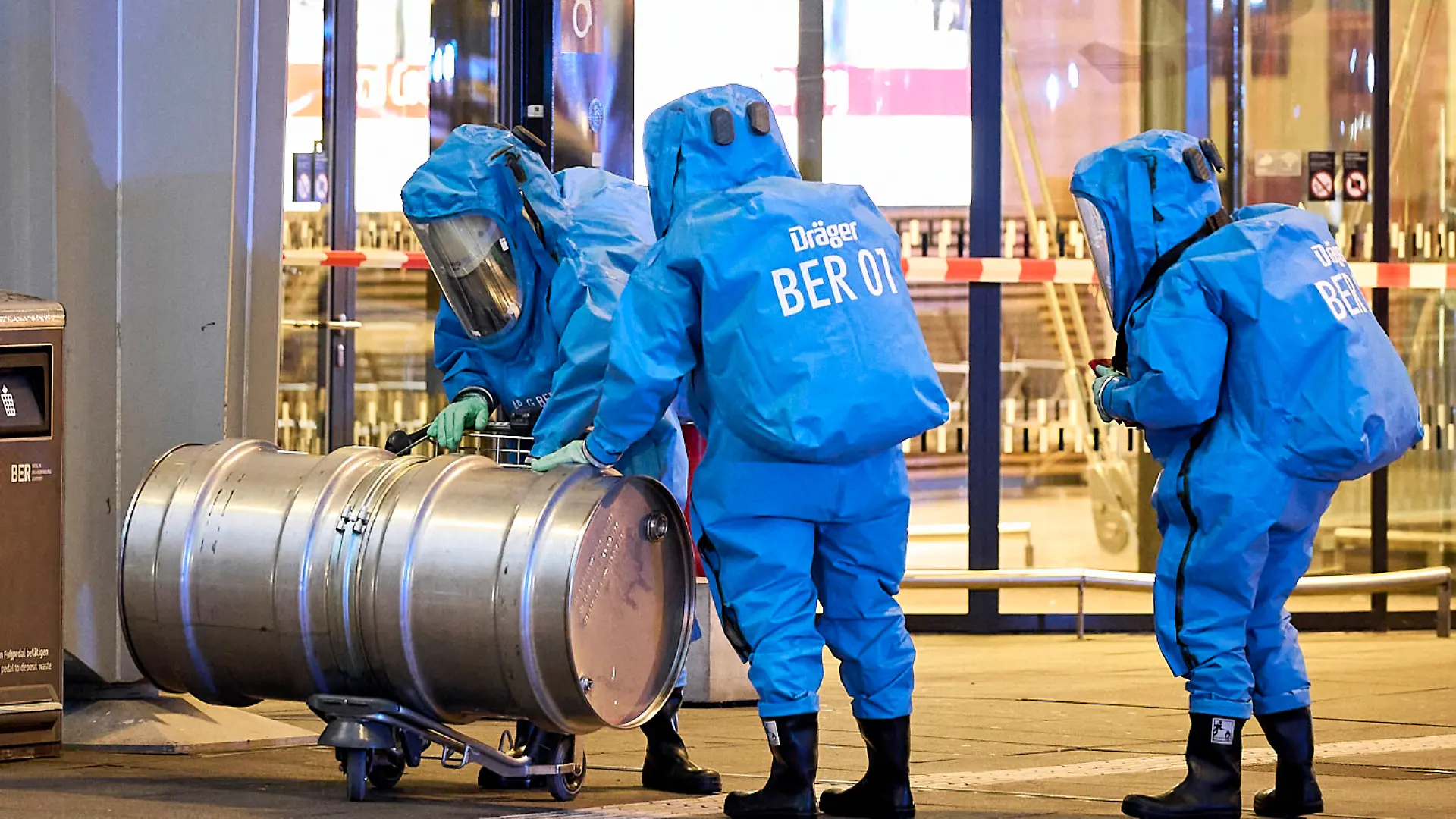 Mitglieder der Feuerwehr in Chemikalienschutzanzüge sind im Einsatz vor dem Terminal 1 am Flughafen BER. Wegen eines möglicherweise gefährlichen Stoffes ist der Terminal 1 des Hauptstadtflughafens BER am Abend teilweise geräumt worden. Die Fluggäste wurden aufgefordert, das Gebäude zu verlassen, wie ein Sprecher der Bundespolizei sagte. Demnach habe eine Frau beim Servicepoint der Bundespolizei gesagt, sie habe einen gefährlichen Stoff dabei.
