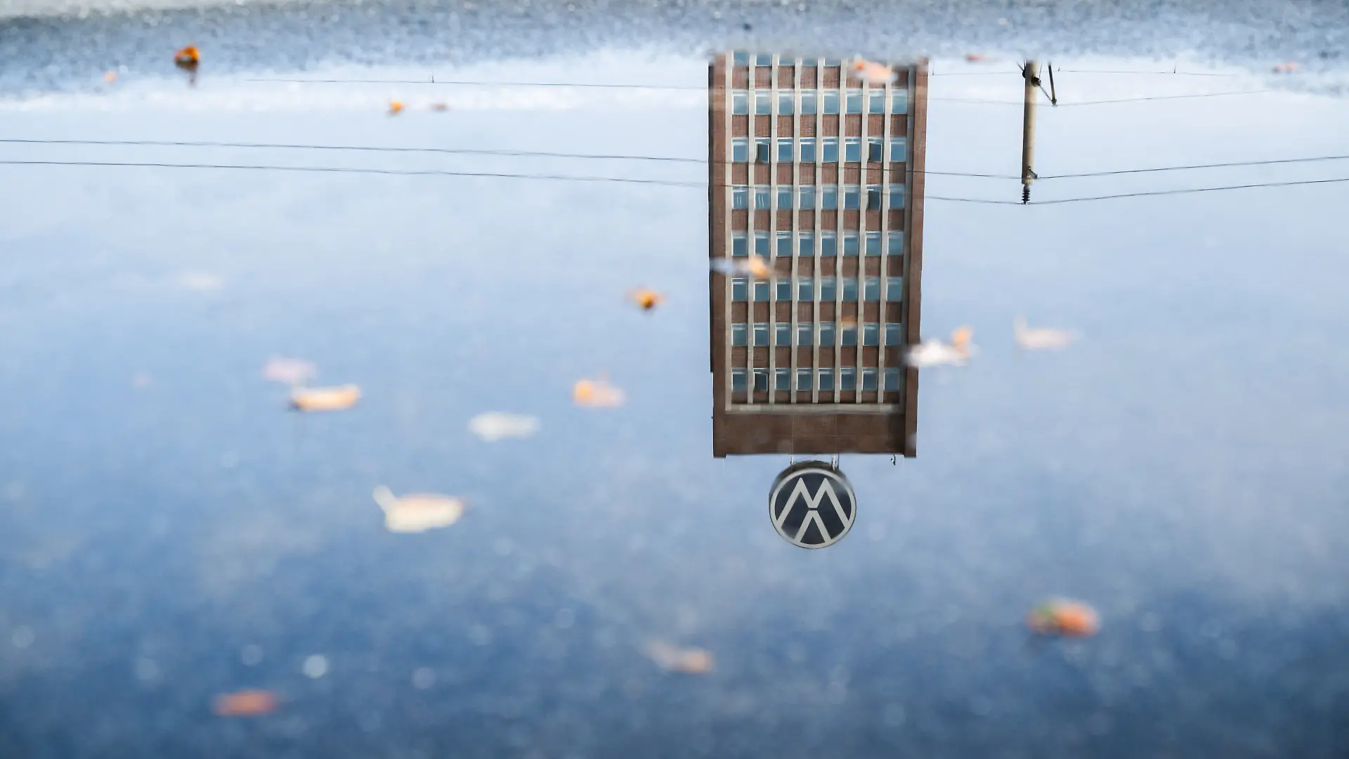 Das Markenhochhaus am VW-Stammwerk spiegelt sich in einer Pfütze. Zehntausende Mitarbeiter bei Volkswagen bangen aufgrund drohender Werkschließungen um ihre Jobs.