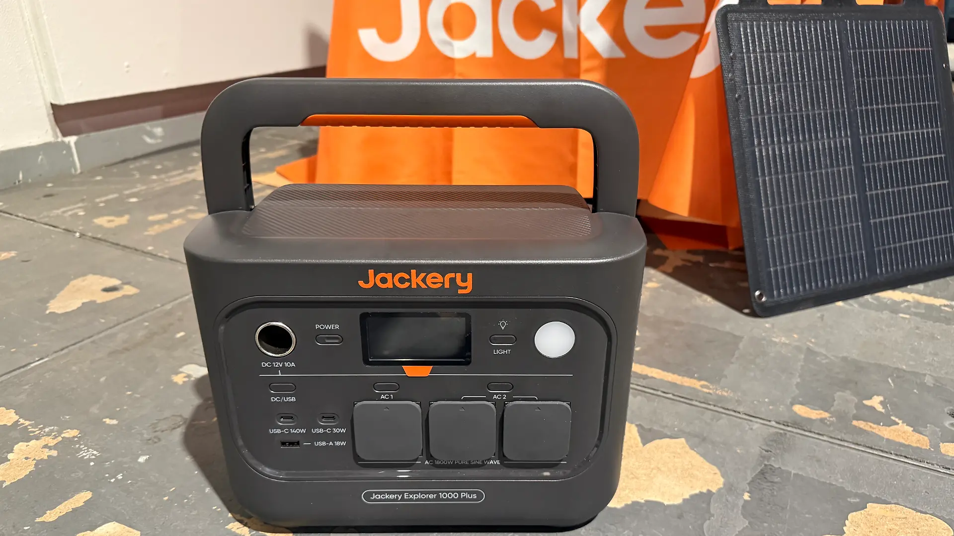 Jackery Explorer 1000 Plus mit Solarpanel im Hintergrund