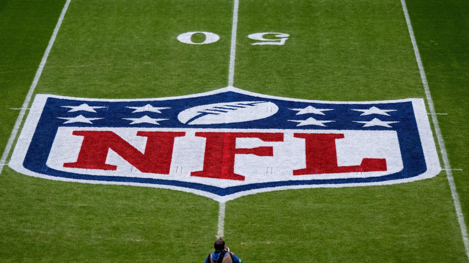 ARCHIV - 13.11.2022, Bayern, München: American Football, NFL, Tampa Bay Buccaneers - Seattle Seahawks, 10. Spieltag, Hauptrunde in der Allianz Arena: Das Logo der NFL ist vor dem Spiel auf dem Rasen zu sehen. Die NFL ist mit juristischen Untersuchungen konfrontiert. (zu dpa: «Diskriminierungsvorwürfe: NFL im Visier der Justiz») Foto: Sven Hoppe/dpa +++ dpa-Bildfunk +++