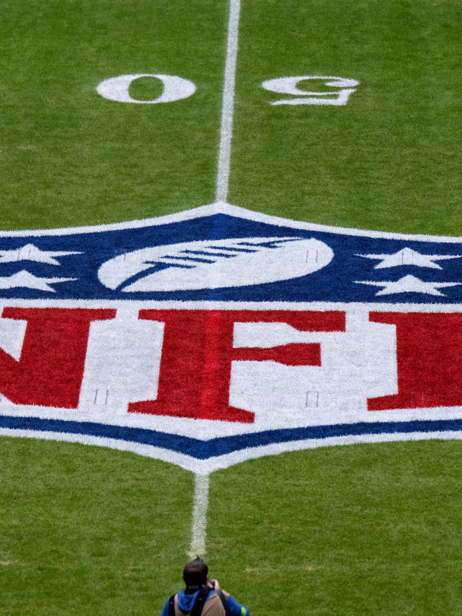 ARCHIV - 13.11.2022, Bayern, München: American Football, NFL, Tampa Bay Buccaneers - Seattle Seahawks, 10. Spieltag, Hauptrunde in der Allianz Arena: Das Logo der NFL ist vor dem Spiel auf dem Rasen zu sehen. Die NFL ist mit juristischen Untersuchungen konfrontiert. (zu dpa: «Diskriminierungsvorwürfe: NFL im Visier der Justiz») Foto: Sven Hoppe/dpa +++ dpa-Bildfunk +++