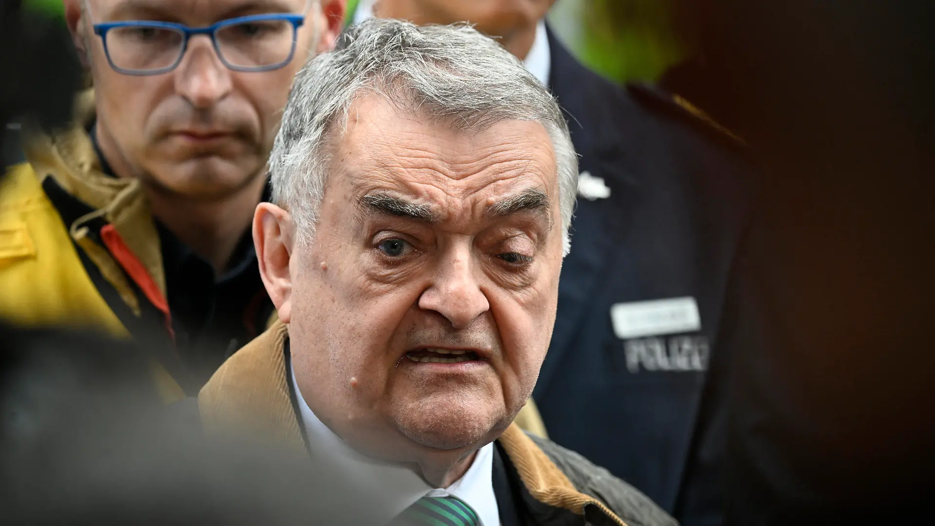 11.05.2023, Nordrhein-Westfalen, Ratingen: Herbert Reus (CDU), Innenminister von Nordrhein-Westfalen, spricht am Tatort zu den Journalisten. Nach der Explosion in einem Ratinger Hochhaus ist in der Wohnung eine Leiche gefunden worden. Zuvor hatten Spezialkräfte die Wohnung gestürmt und einen etwa 60 Jahre alten Mann festgenommen. Bei der Explosion waren zehn Feuerwehrleute und zwei Polizeibeamte verletzt worden - einige von ihnen sehr schwer. Foto: -/dpa +++ dpa-Bildfunk +++