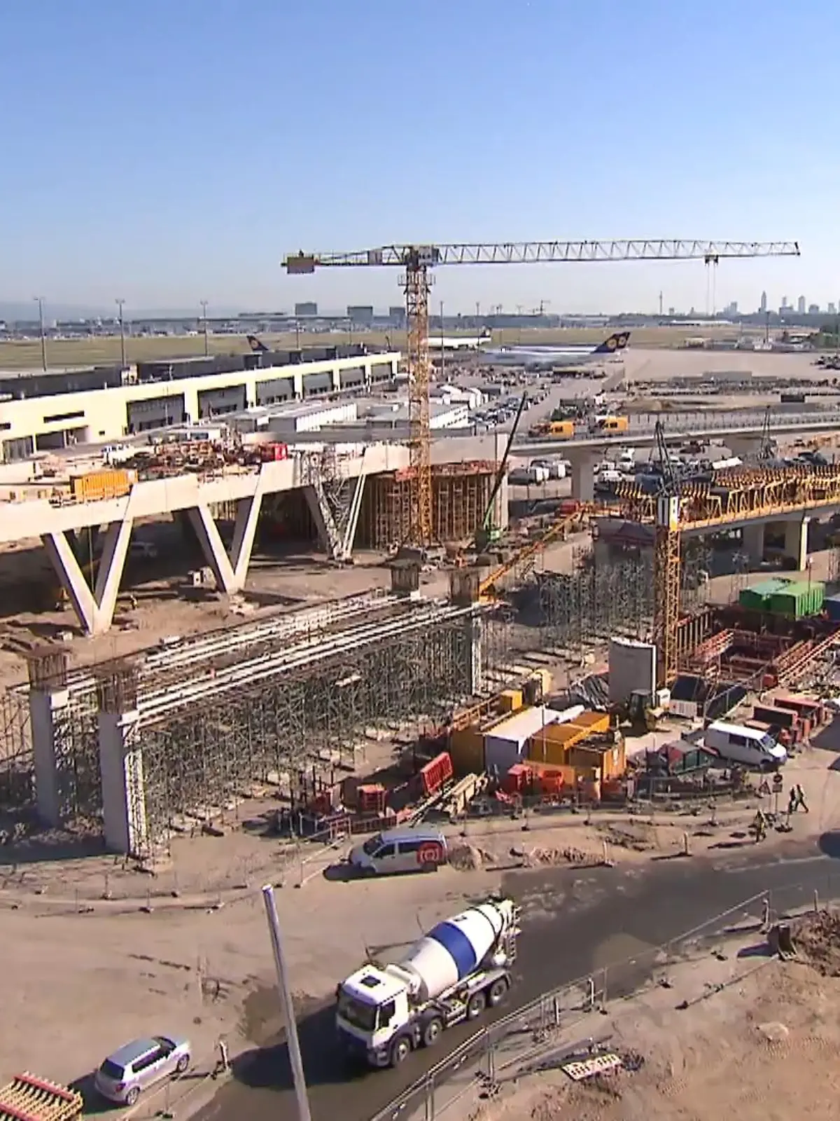Die Arbeiten laufen auf Hochtouren. Entstehen sollen zehn Kilometer neue Straßen mit Anbindung an die A5, ein neues Parkhaus mit über acht Tausend Parkplätzen, eine Hightech-Skyline-Bahn und natürlich große Hallen für den Flugbetrieb. Kosten für das gigantische Projekt: Rund vier Milliarden Euro.