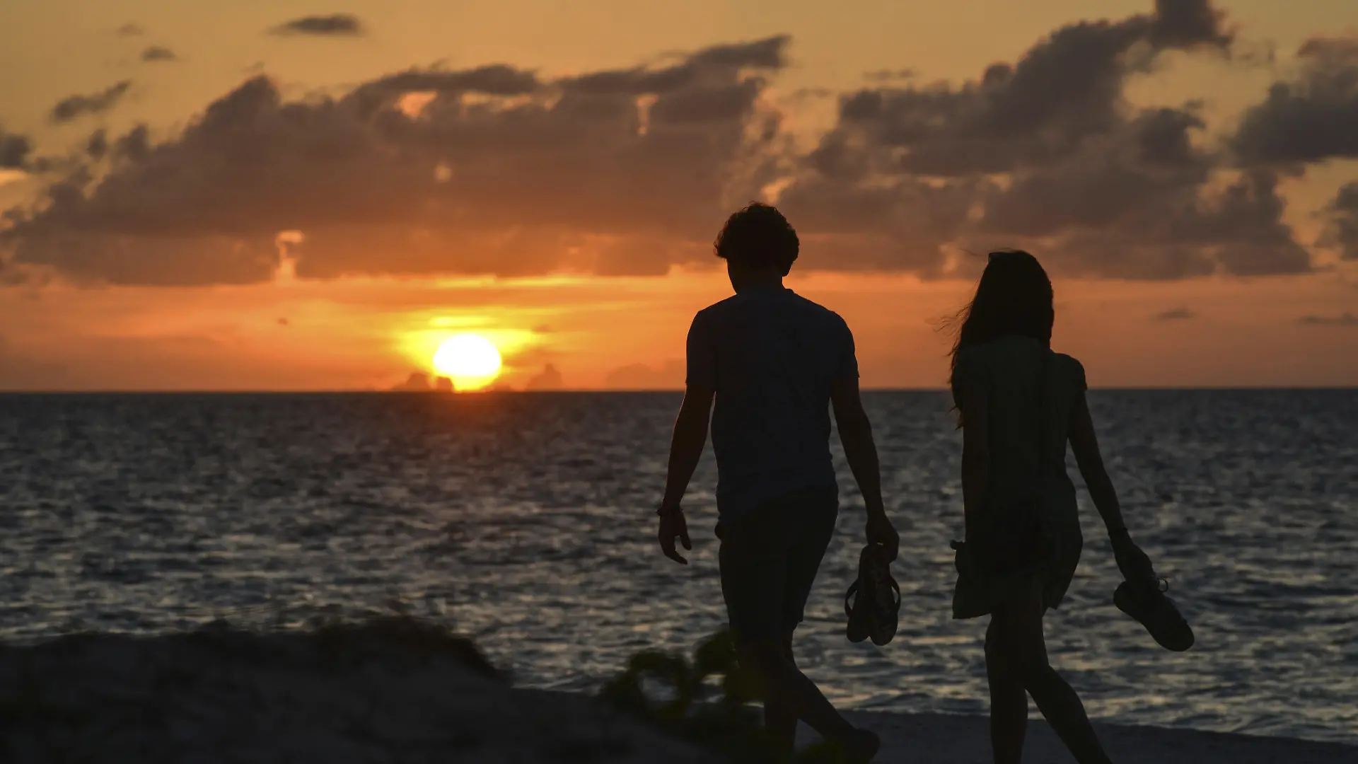 Paar spaziert bei Sonnenuntergang am feinen Sandstrand von Cayo Levisa, im Colorados Archipel, Golf von Mexiko, Nordküste, Kuba, Provinz Pinar del Rio