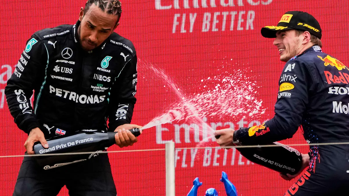 dpatopbilder - 20.06.2021, Frankreich, Le Castellet: Motorsport: Formel-1-Weltmeisterschaft, Großer Preis von Frankreich. Sieger Max Verstappen (r) aus den Niederlanden vom Team Red Bull Racing und der Zweitplatzierte Lewis Hamilton aus Großbritannien vom Team Mercedes lassen auf dem Podium Champagner aus einer Flasche spritzen. Foto: Francois Mori/AP/dpa +++ dpa-Bildfunk +++
