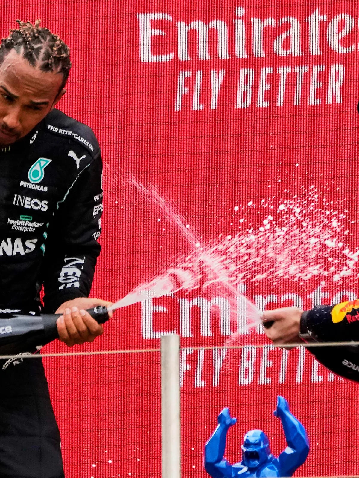 dpatopbilder - 20.06.2021, Frankreich, Le Castellet: Motorsport: Formel-1-Weltmeisterschaft, Großer Preis von Frankreich. Sieger Max Verstappen (r) aus den Niederlanden vom Team Red Bull Racing und der Zweitplatzierte Lewis Hamilton aus Großbritannien vom Team Mercedes lassen auf dem Podium Champagner aus einer Flasche spritzen. Foto: Francois Mori/AP/dpa +++ dpa-Bildfunk +++