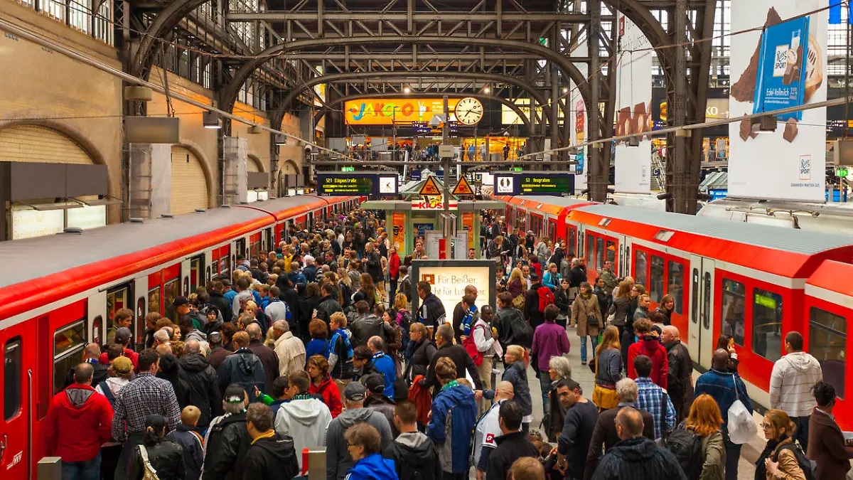 "Hamburg, Germany - September 17, 2011: Crowded station platform of the Hamburg S-Bahn at the Hamburg hauptbahnhof. Many people can be seen on the platform, some of which can be seen wearing scarves and blue jerseys to support a local football team."