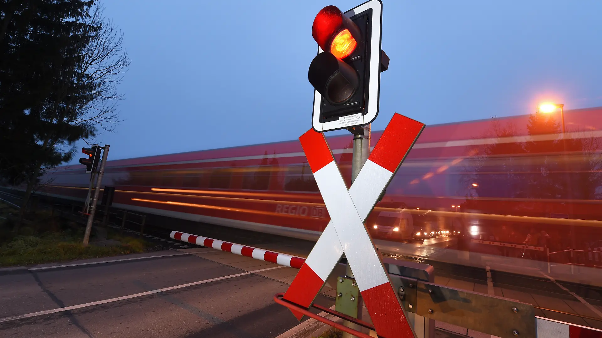 Ein Regionalexpress fährt am 17.11.2014 in Oberzell (Baden-Württemberg) an einem beschrankten Bahnübergang vorbei. Am 17.11. 2014 findet in Friedrichshafen ein Spitzentreffen zur Finanzierung der Südbahn-Elektrifizierung statt. Foto: Felix Kästle/dpa