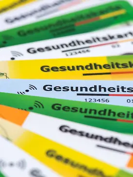 Verschiedene Gesundheitskarten von Krankenversicherungen liegen zusammen als Symbolbild für das Gesundheitssystem basierend auf gesetzlichen Krankenkassen - NUR FÜR REDAKTIONELLE VERWENDUNG -