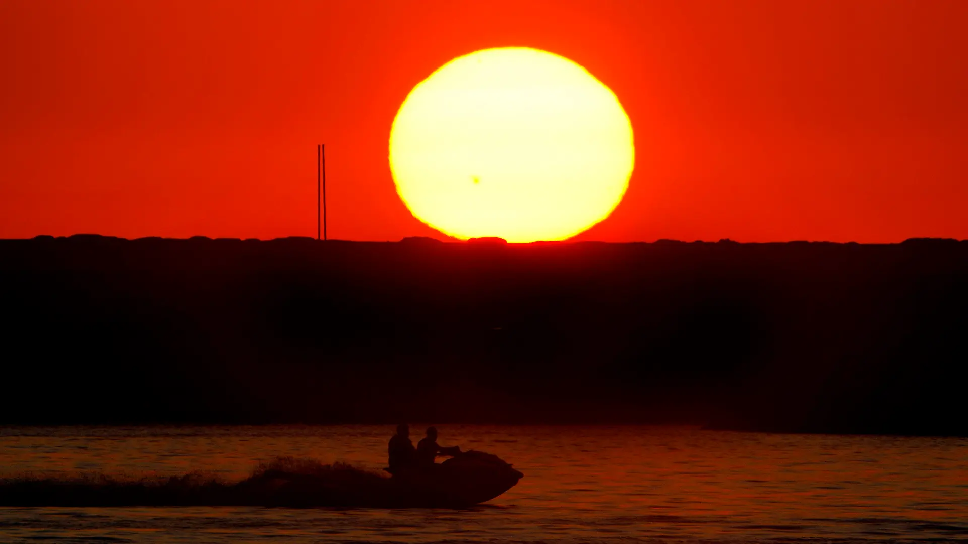 Two men ride a jet ski as the sun sets over the Mediterranean Sea coastline in Beirut, Lebanon, Wednesday, July 12, 2023. (AP Photo/Bilal Hussein)