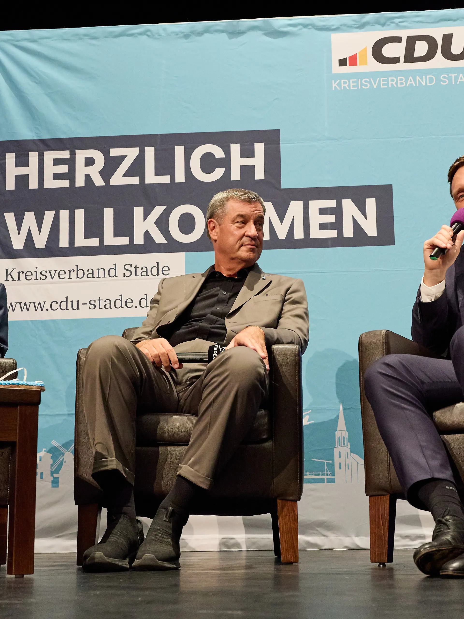 Landrat Kai Seefried (l-r, CDU), Markus Söder (CSU), Bayerischer Ministerpräsident und CSU-Landesvorsitzender, sowie Sebastian Lechner (CDU), Landesvorsitzender der CDU in Niedersachsen, sitzen im Stadeum auf der Bühne. Bayerns Ministerpräsident Söder (CSU) kam zu Besuch nach Niedersachsen. Im Rahmen der Veranstaltung «Niedersachsen trifft Bayern» sprach Markus Söder u.a. mit dem Vorsitzenden der CDU Niedersachsen, Sebastian Lechner, über aktuelle politische Themen und die anstehende Kommunalwahl.