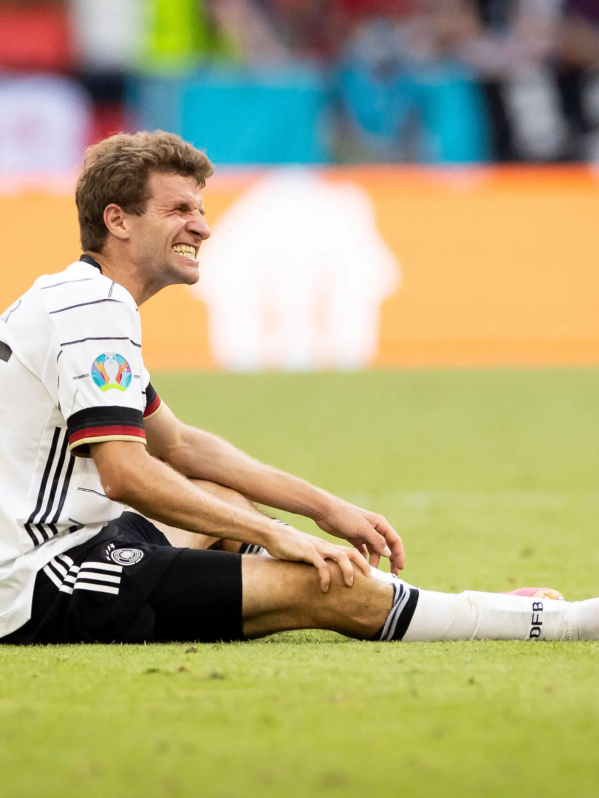 ARCHIV - 19.06.2021, Bayern, München: Fußball: EM, Portugal - Deutschland, Vorrunde, Gruppe F, 2. Spieltag, in der EM-Arena München. Deutschlands Thomas Müller sitzt auf dem Rasen. Müller konnte wegen einer Kapselverletzung am Knie nicht mit der Fußball-Nationalmannschaft im Adi-Dassler-Stadion in Herzogenaurach trainieren. (zu «Müller, Hummels und Gündogan fehlen im DFB-Training - Gosens dabei») Foto: Christian Charisius/dpa +++ dpa-Bildfunk +++