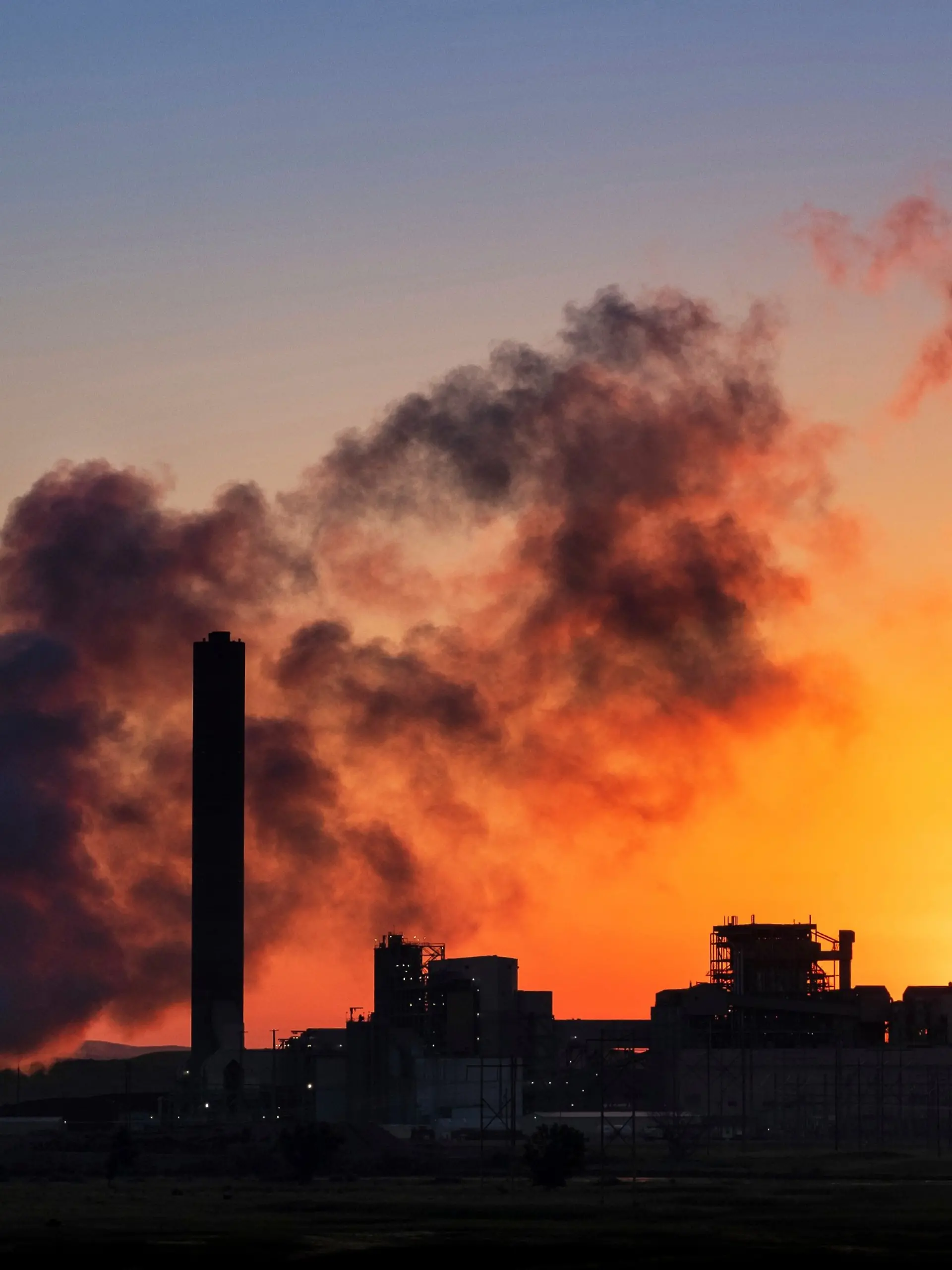 FILE - The Dave Johnson coal-fired power plant is silhouetted against the morning sun in Glenrock, Wyo., July 27, 2018 (AP Photo/J. David Ake, File)