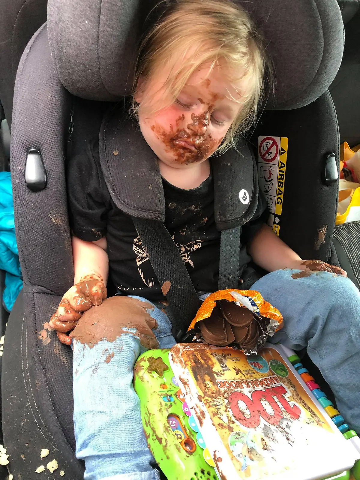 Die kleine, schokoladenverschmierte Lainey (2) in Mamas Auto.